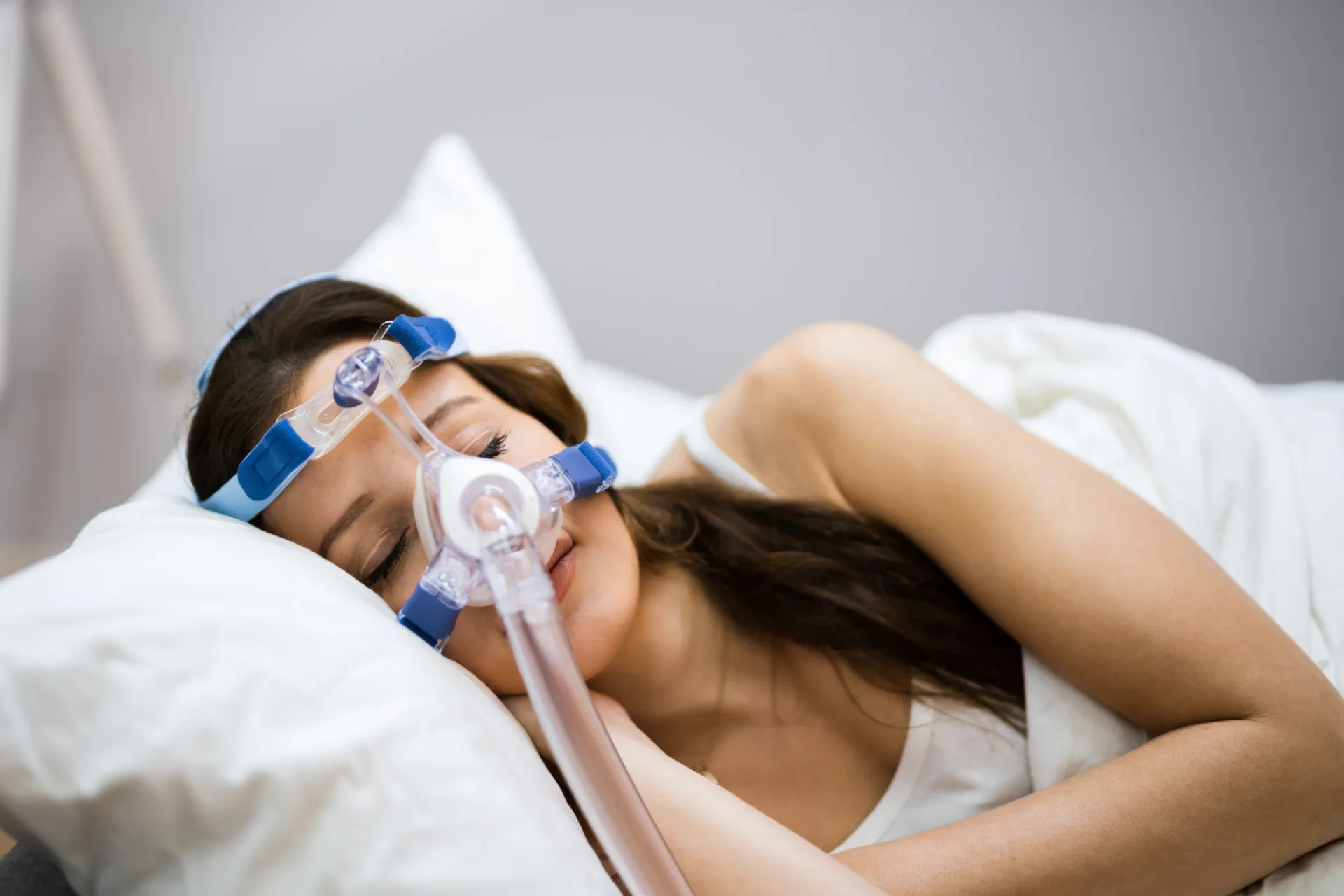 Pessoa usando uma máscara de CPAP para dormir, conectada a um aparelho.