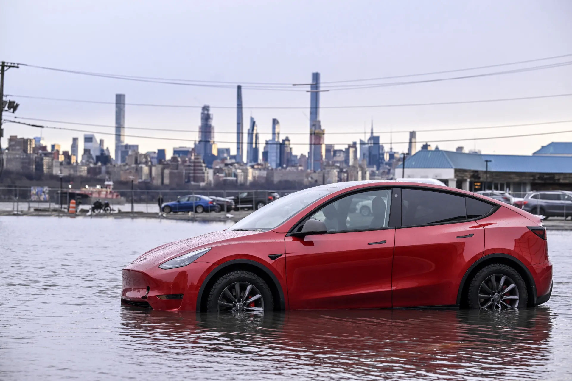 Relógio fazendo contagem regressiva com a imagem de uma bateria de carro elétrico ao fundo.