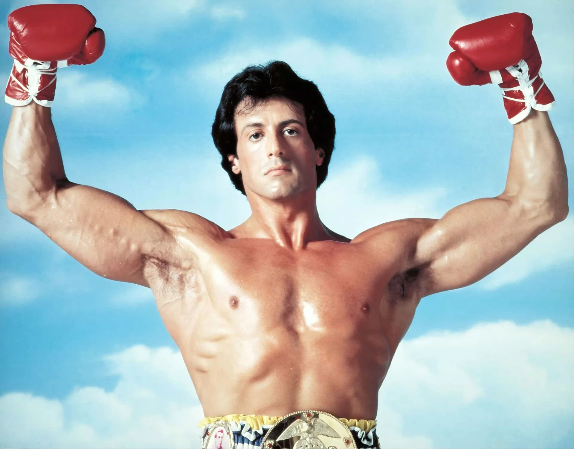 Sylvester Stallone como Rocky Balboa, com um corpo extremamente magro e definido, mostrando cada músculo.