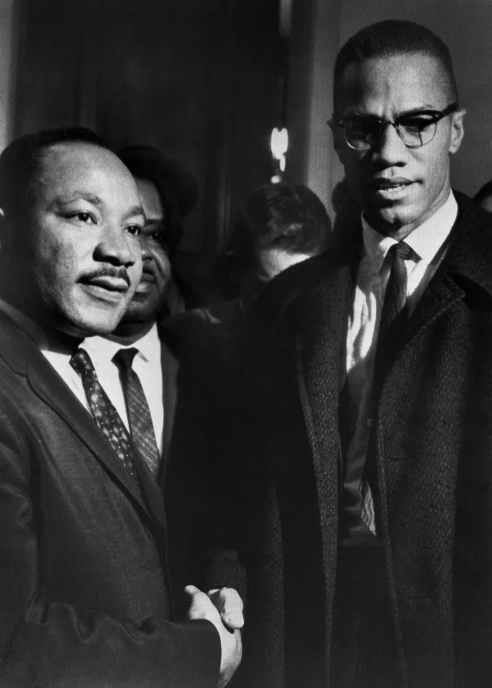 Martin Luther King Jr. e Malcolm X conversando e sorrindo durante seu único encontro.