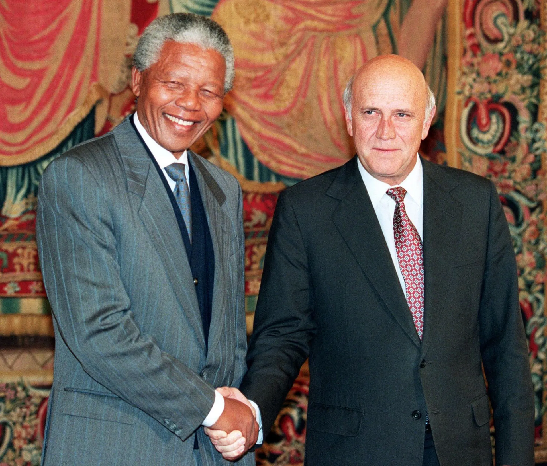 Nelson Mandela e F.W. de Klerk sorrindo juntos, simbolizando a transição pacífica na África do Sul.