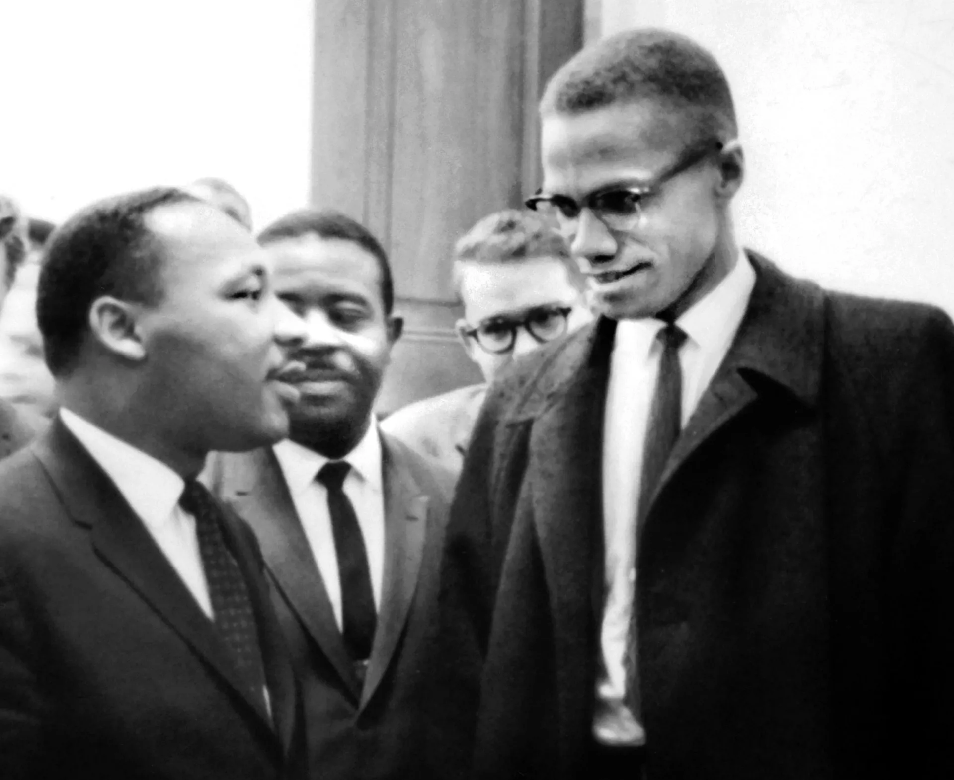 Fotografia histórica de Martin Luther King Jr. e Malcolm X se cumprimentando no Capitólio.