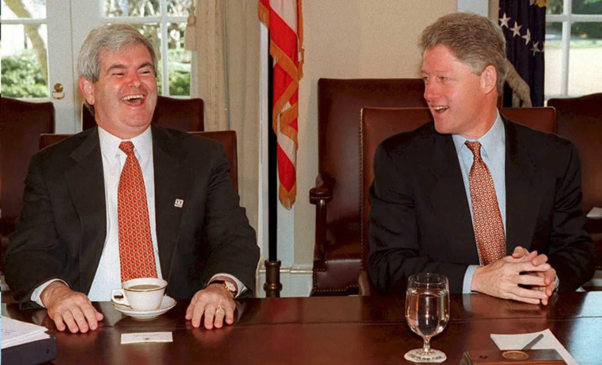 Clinton e Gingrich apertando as mãos durante a assinatura de um acordo orçamentário.