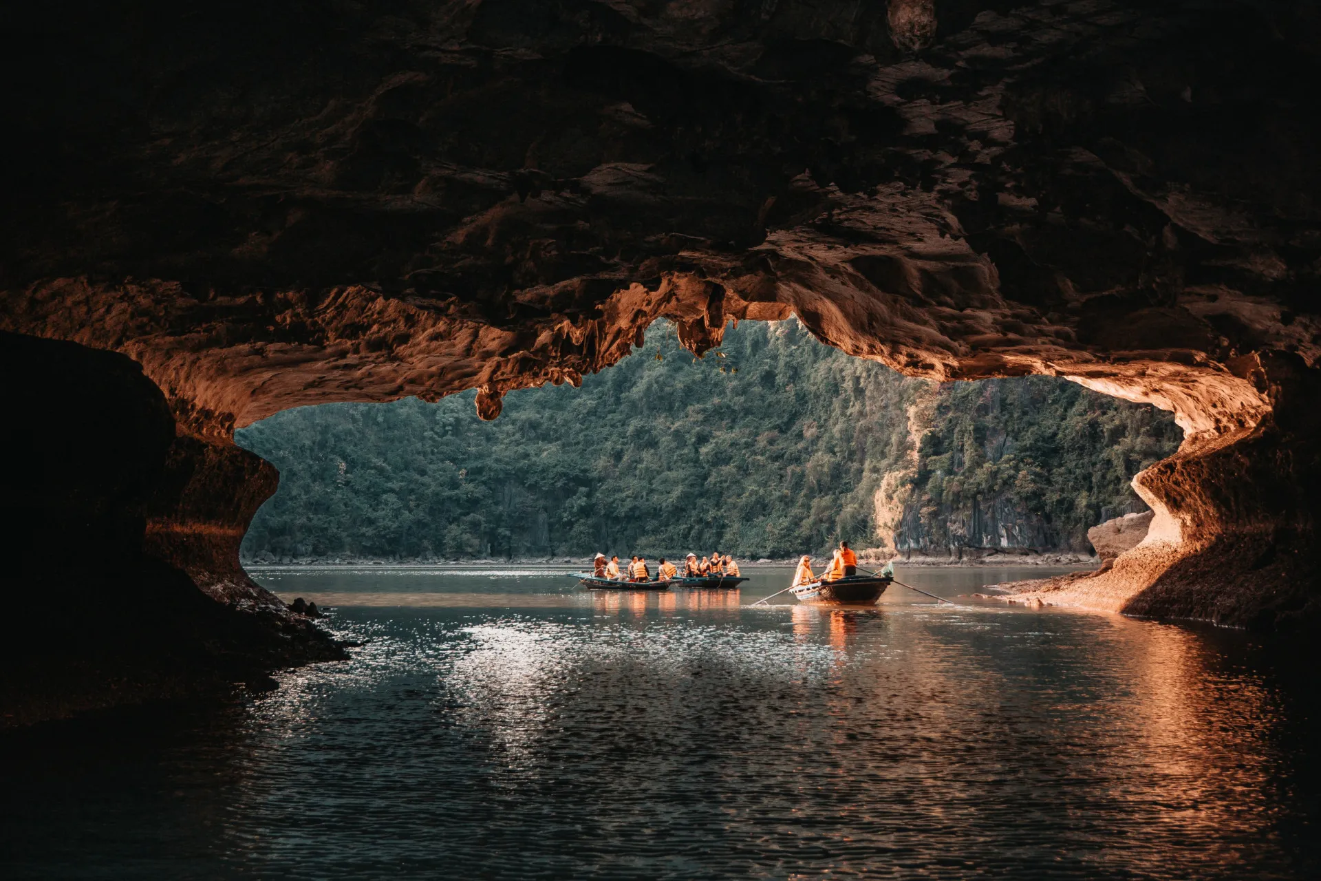 Interior de uma caverna iluminada na Baía de Halong, com formações rochosas impressionantes.