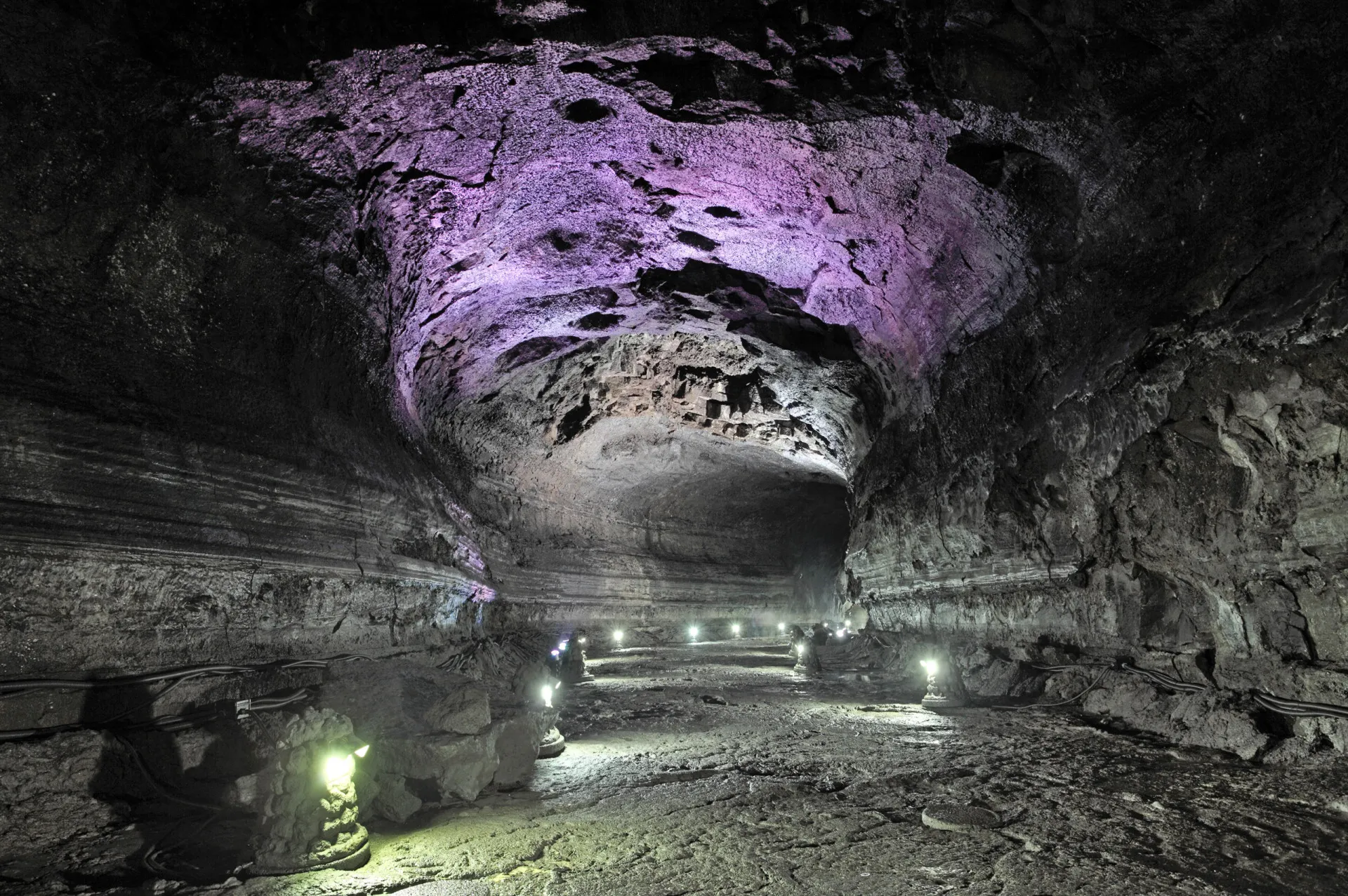 Interior de um dos longos tubos de lava de Jeju, mostrando suas formações geológicas.