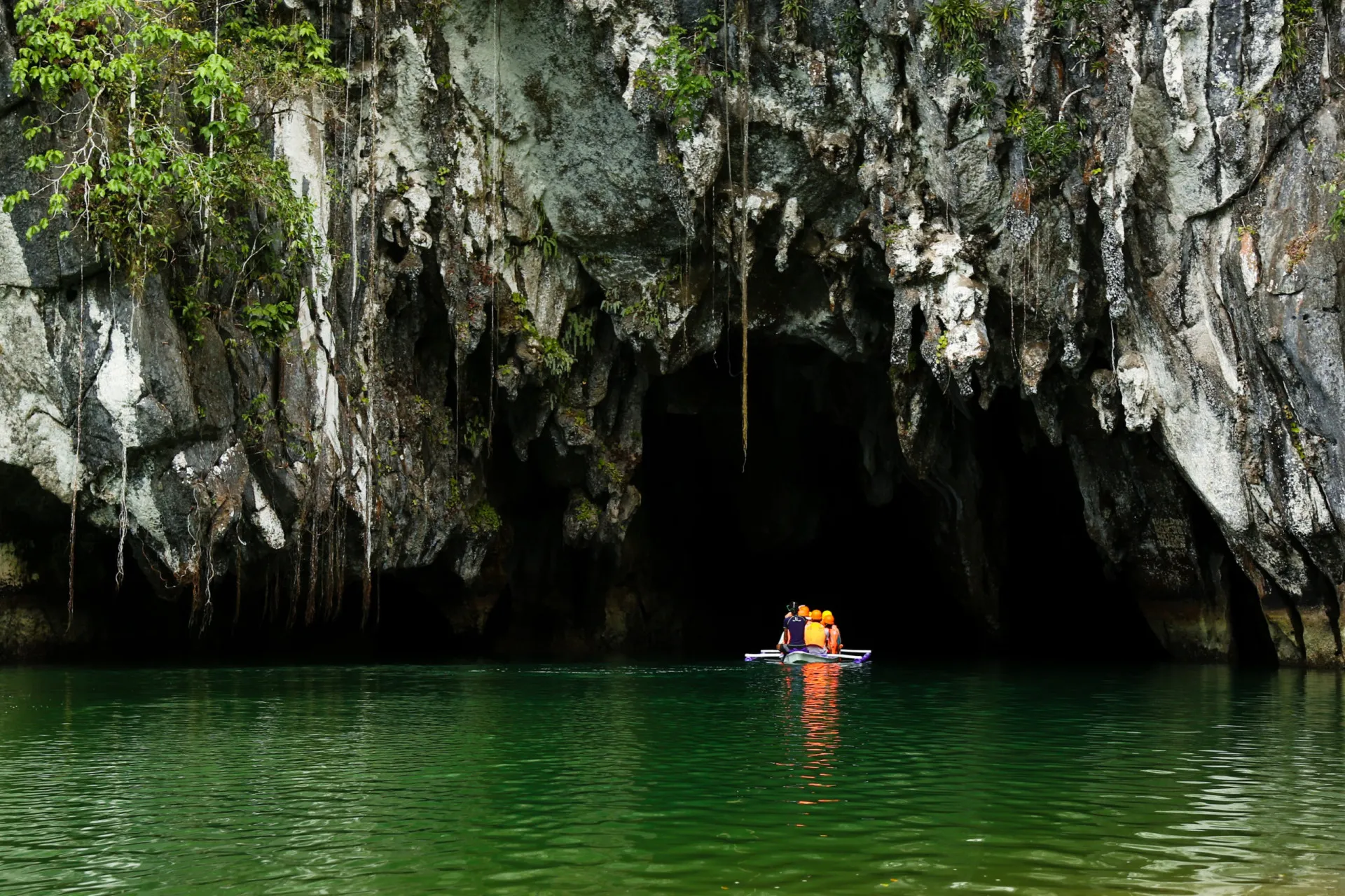 Barco com turistas na entrada da caverna do Rio Subterrâneo Puerto-Princesa.