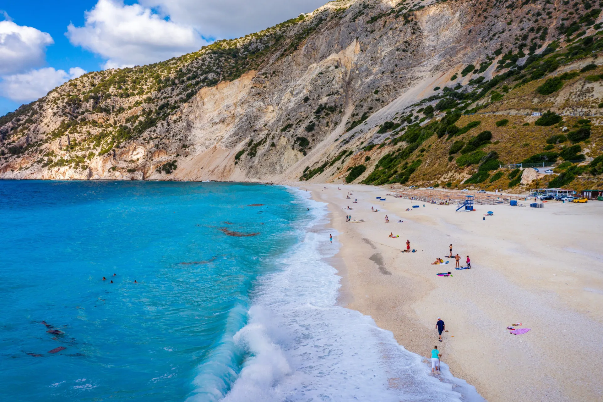 Vista panorâmica da Praia de Myrtos na ilha de Kefalonia, cercada por altas montanhas.