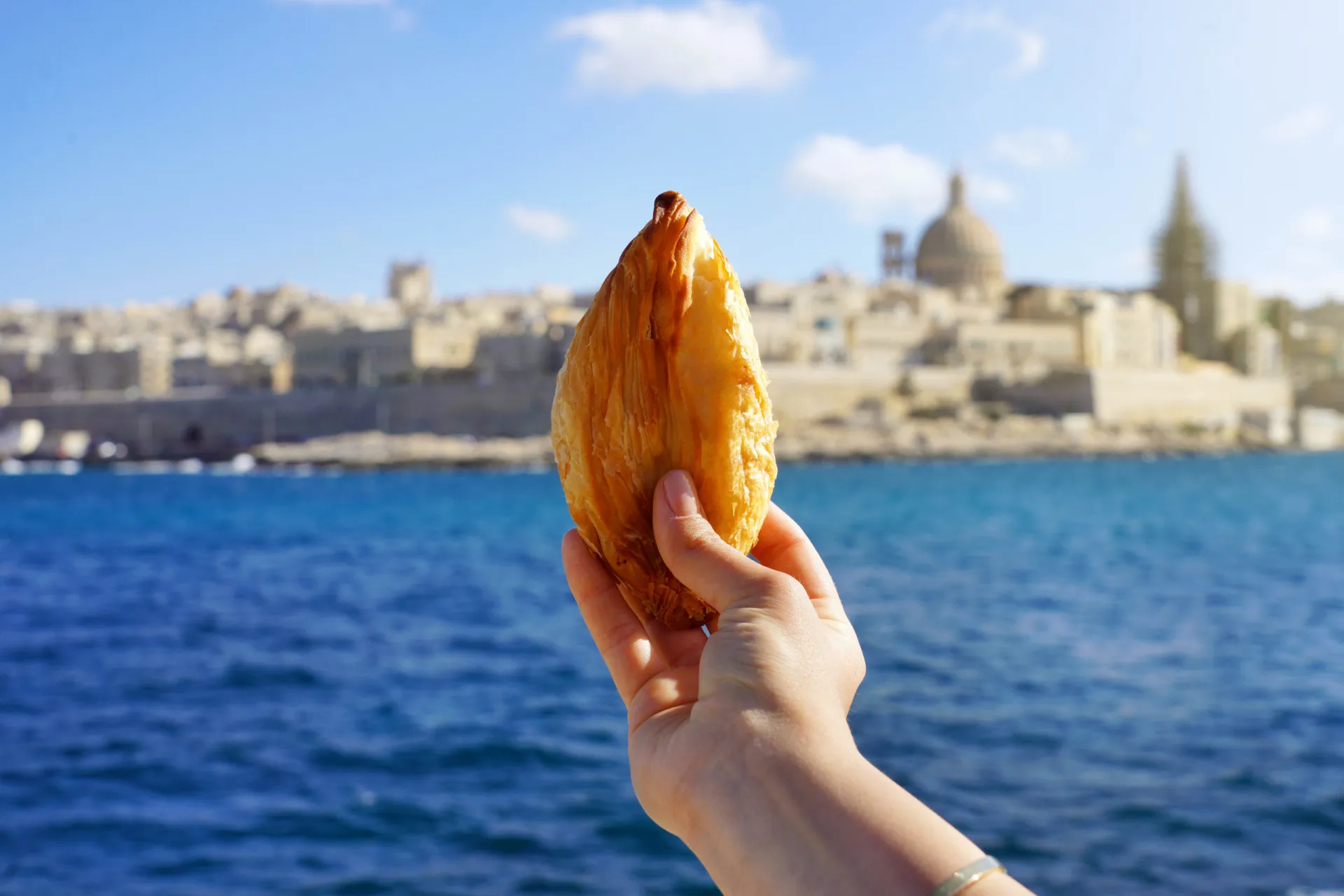 Vista da cidade de Valletta, em Malta, com sua arquitetura histórica e o mar ao fundo.
