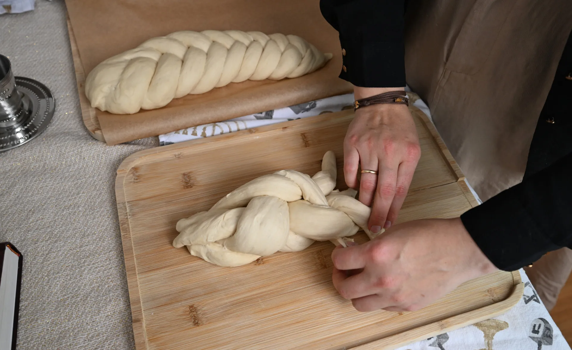 Pão chalá trançado e fresco sobre uma mesa de madeira.