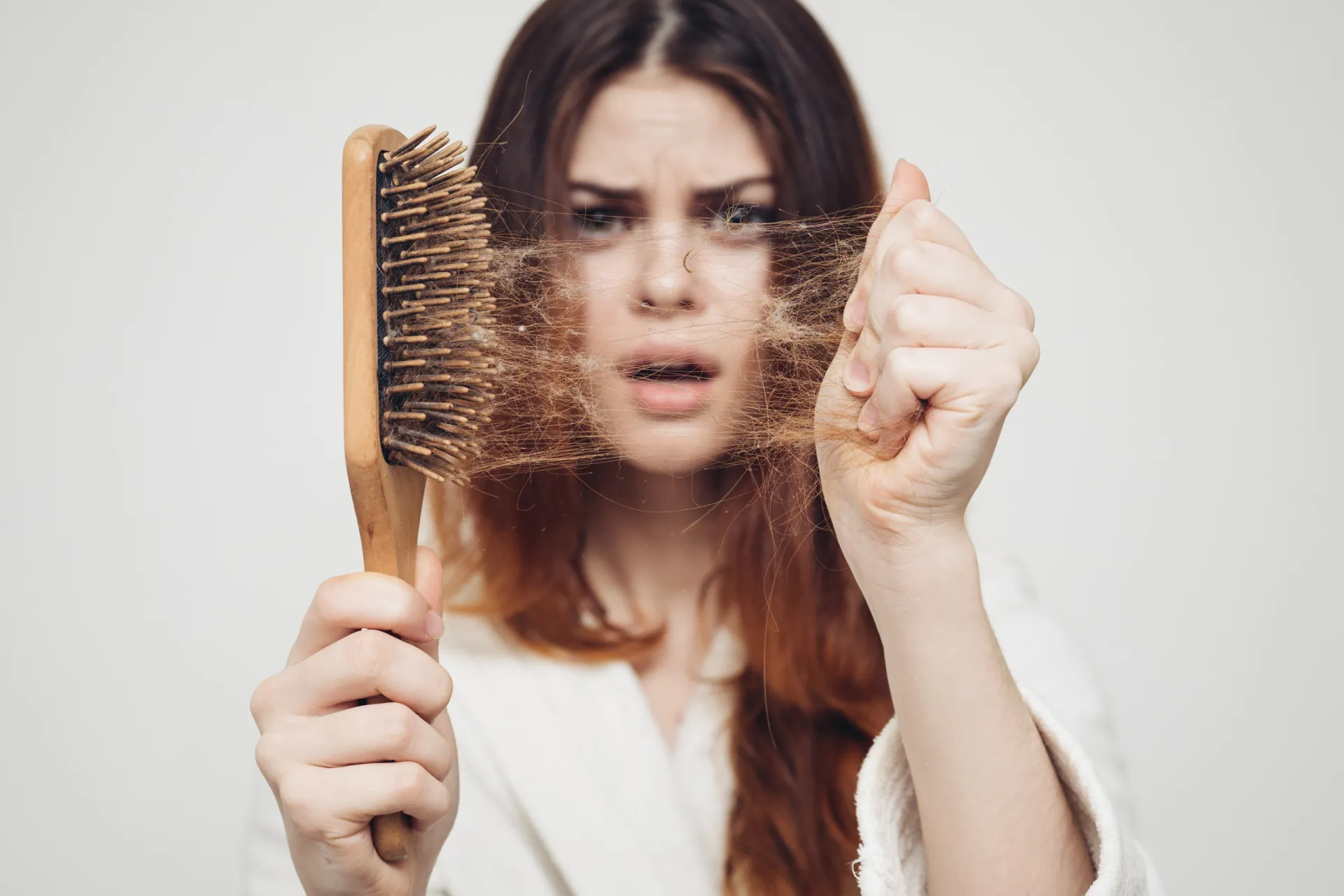 Cabelo caindo em uma escova, simbolizando a perda capilar excessiva.
