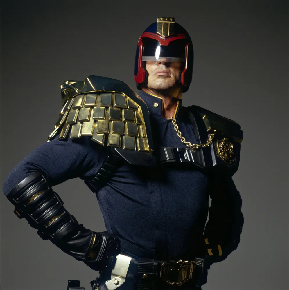 Juiz Dredd, com seu capacete característico que obscurece seu rosto, em uma pose imponente.