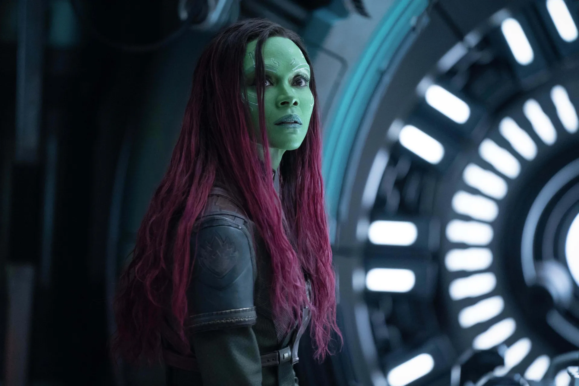 Gamora, interpretada por Zoe Saldana, com sua pele verde e traje de couro, pronta para a batalha.