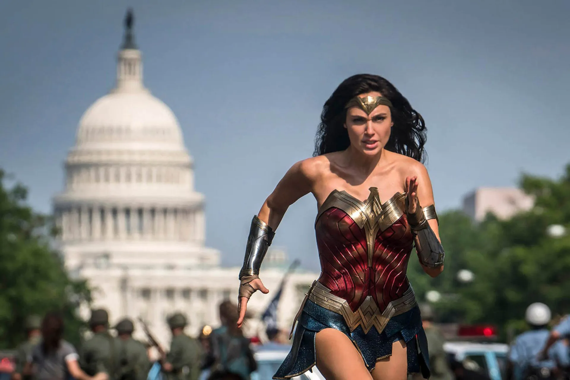 Mulher-Maravilha, interpretada por Gal Gadot, cruzando os braceletes para desviar de balas.
