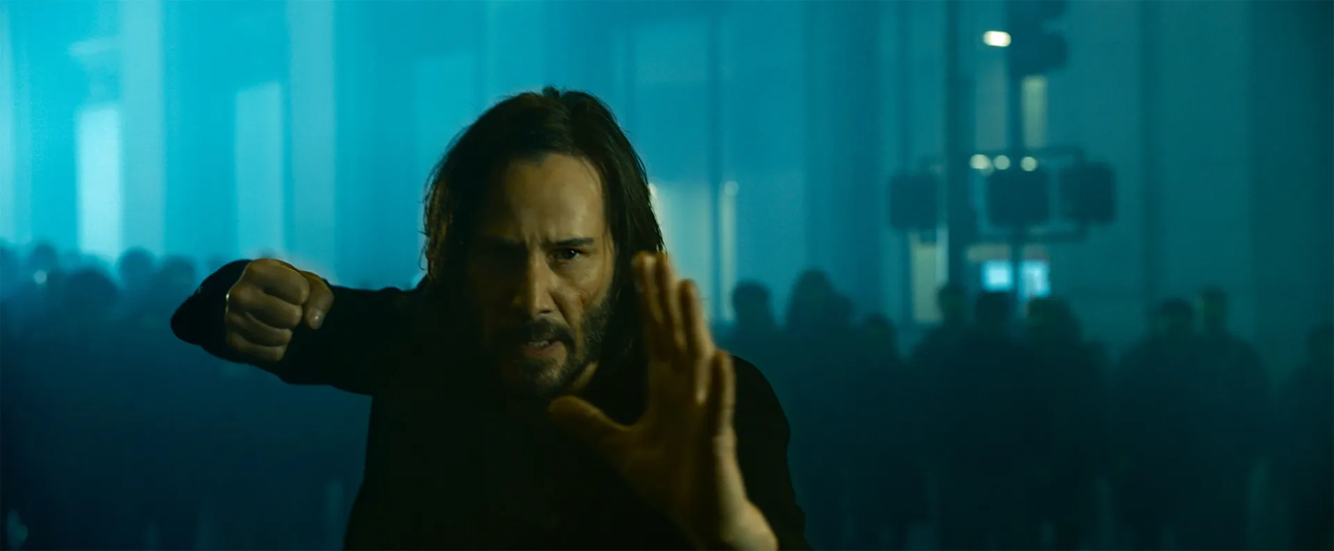Neo, interpretado por Keanu Reeves, de sobretudo preto e óculos escuros, desviando de balas em câmera lenta.
