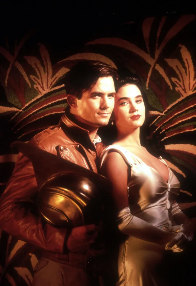 O Rocketeer, com seu capacete dourado icônico e o propulsor a jato nas costas, pronto para voar.