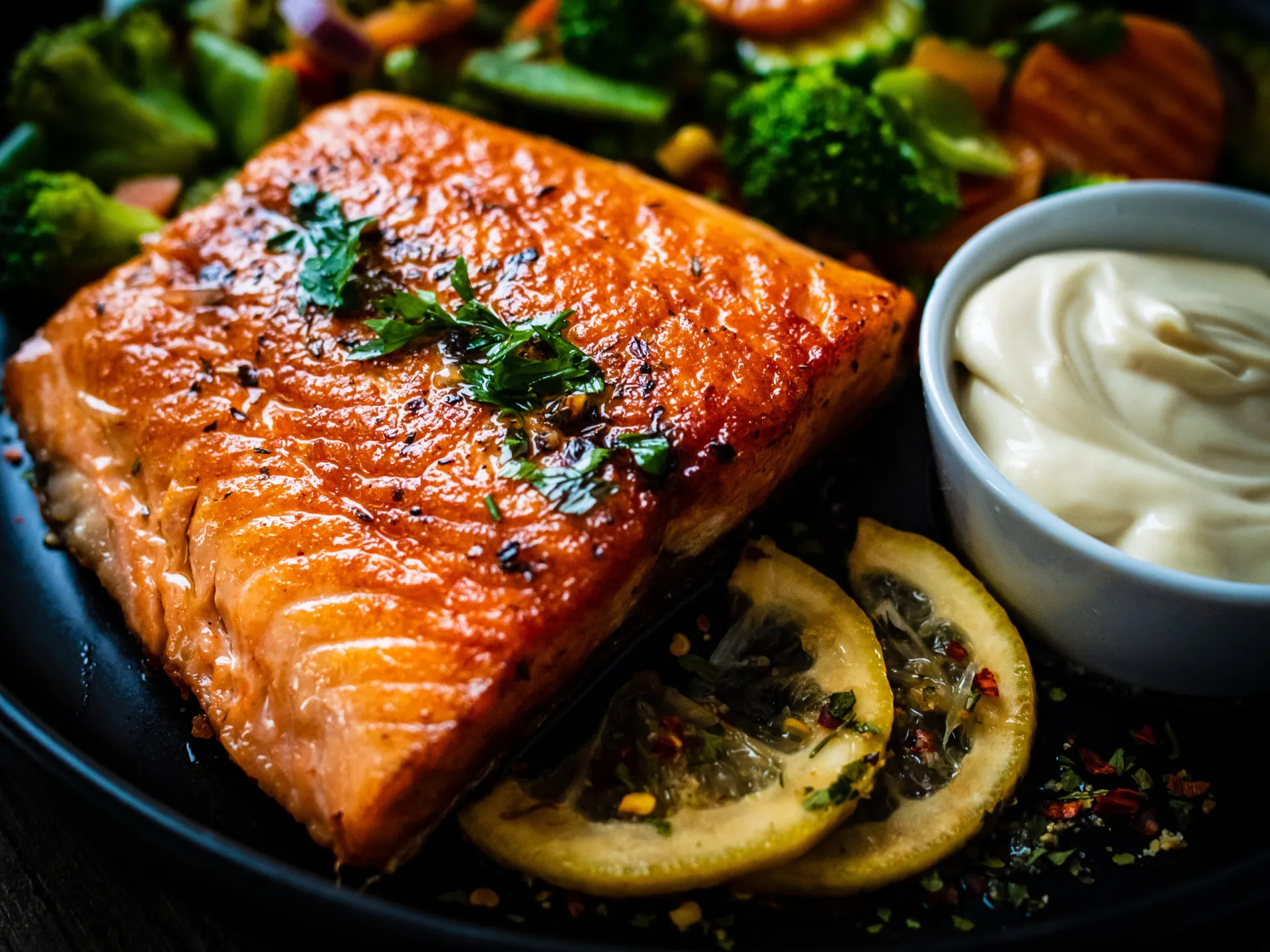 Filé de salmão fresco sendo preparado com ervas e limão.