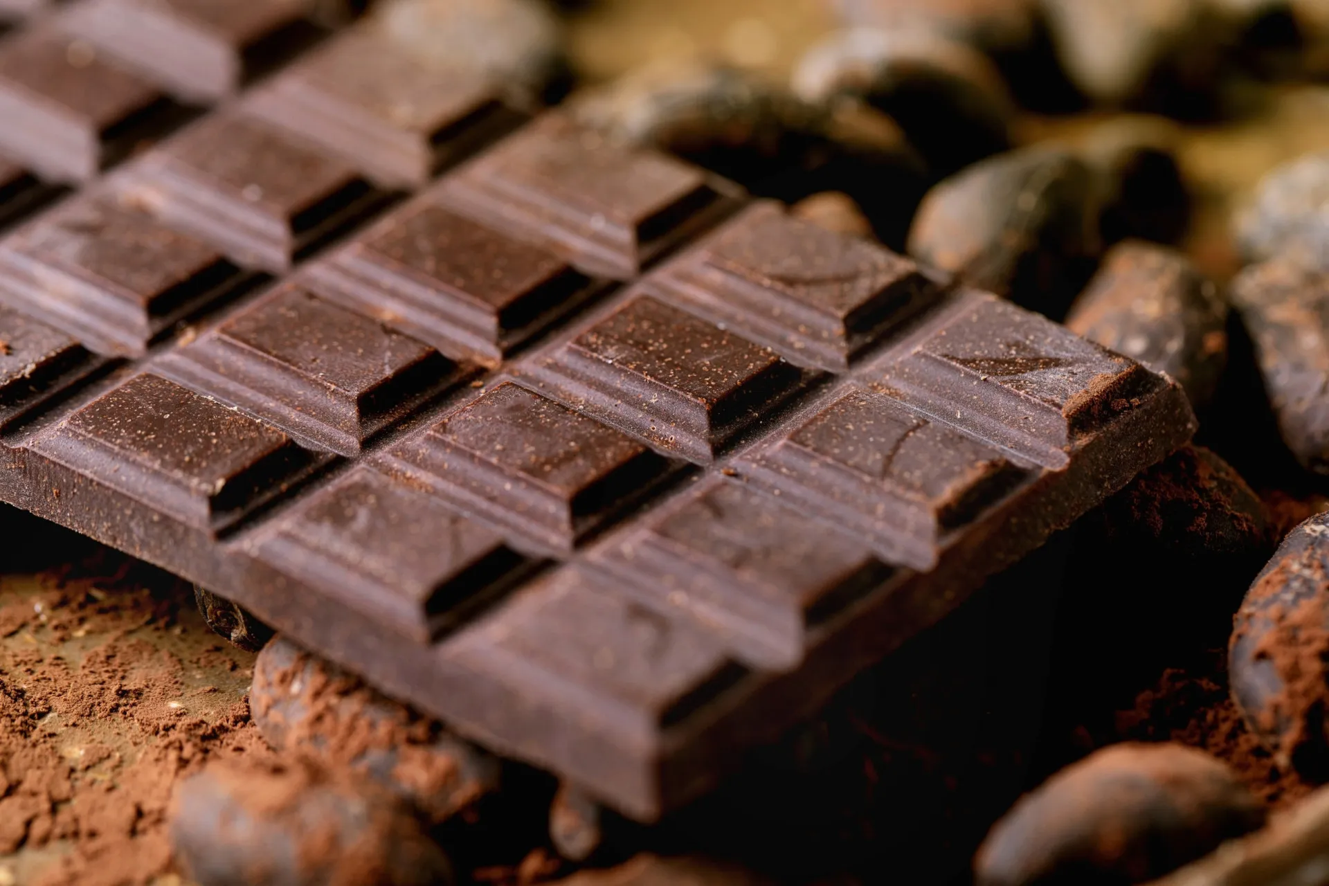 Uma pessoa desfrutando de um pedaço de chocolate amargo como um momento de relaxamento.