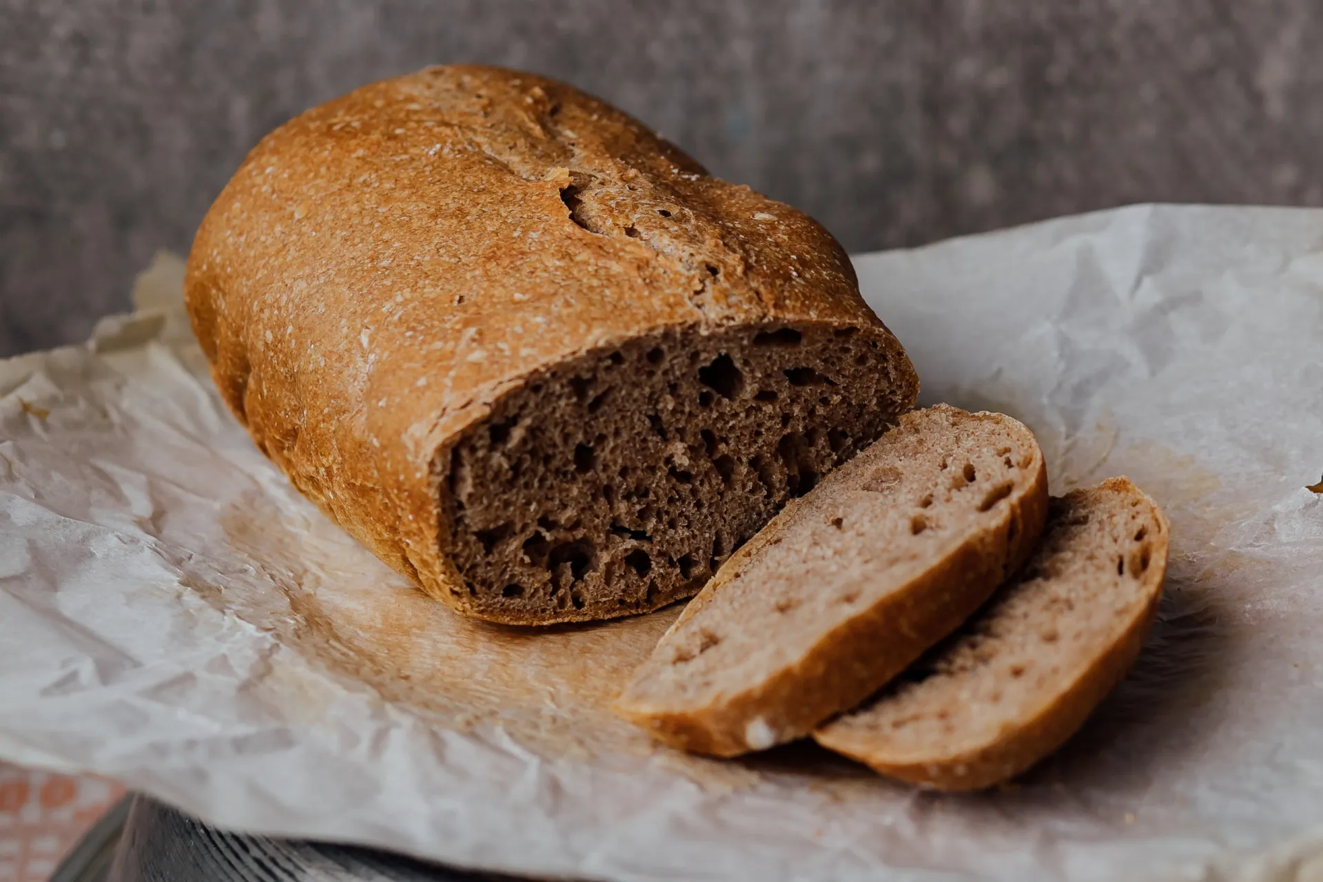 Fatias de pão integral, com grãos visíveis na casca.