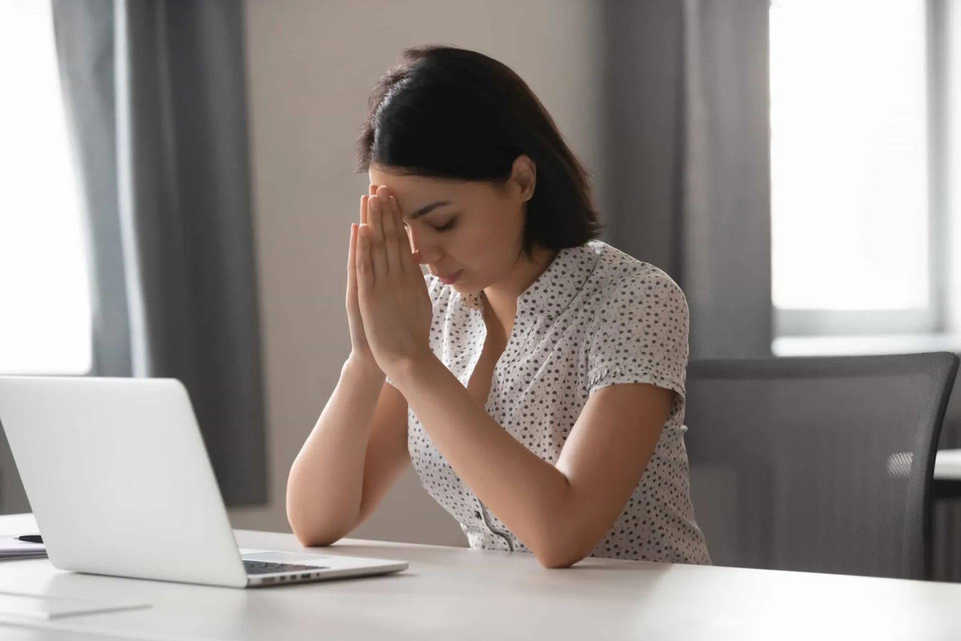 Mulher trabalhando em seu computador enquanto discretamente procura outras vagas de emprego.