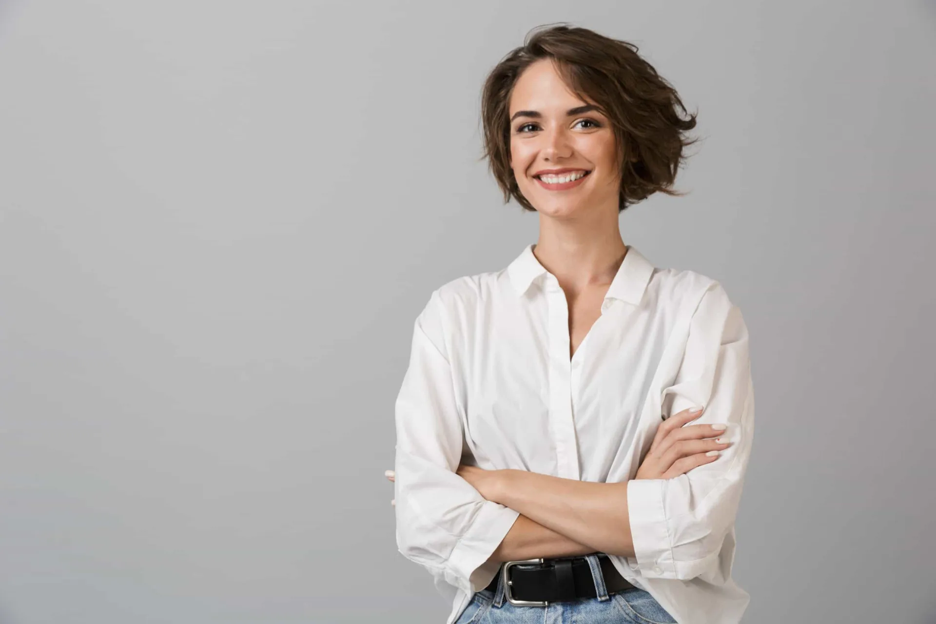 Pessoa no topo de uma montanha com os braços erguidos, simbolizando confiança e sucesso.