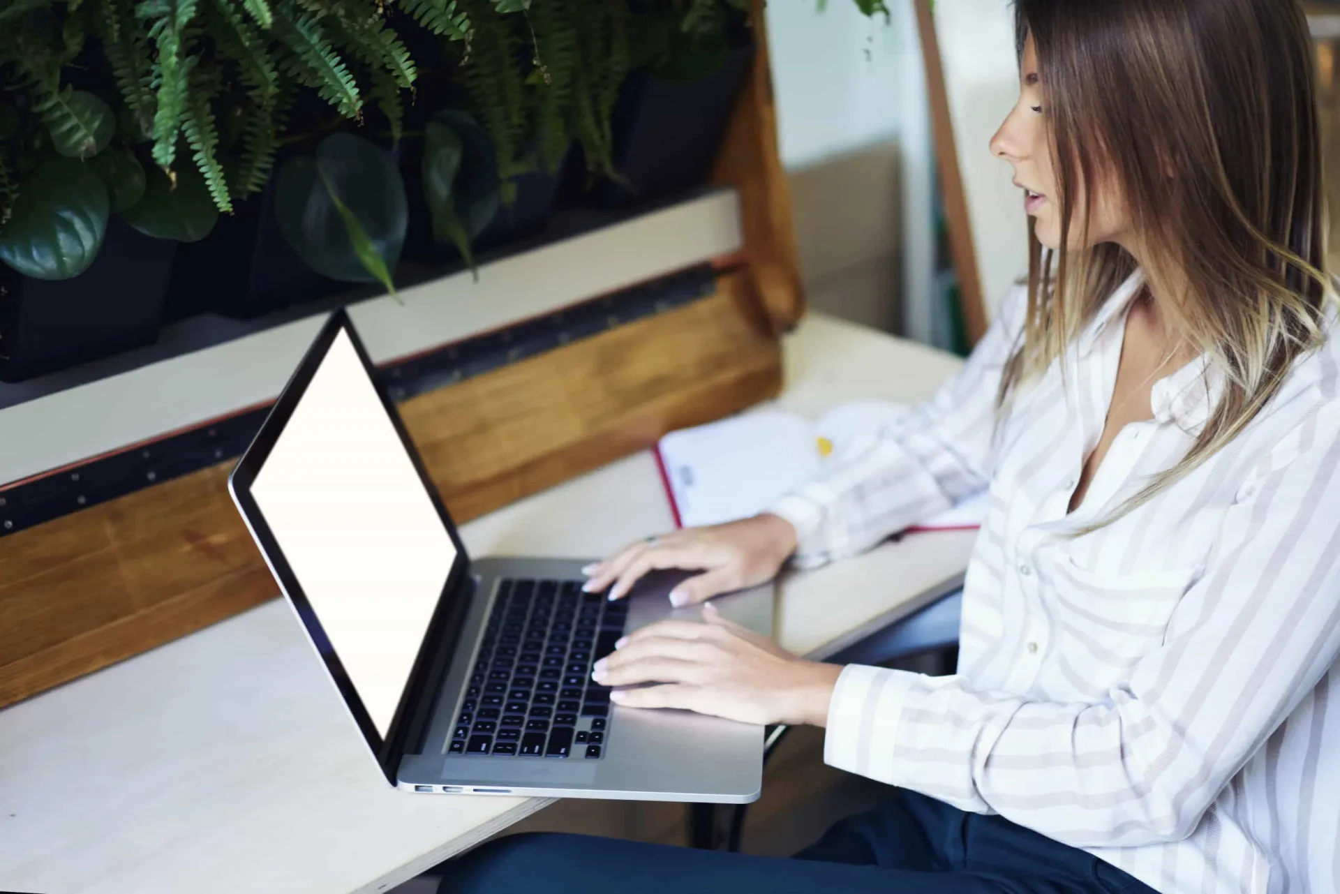 Pessoa escrevendo um e-mail de acompanhamento em um laptop após uma entrevista.