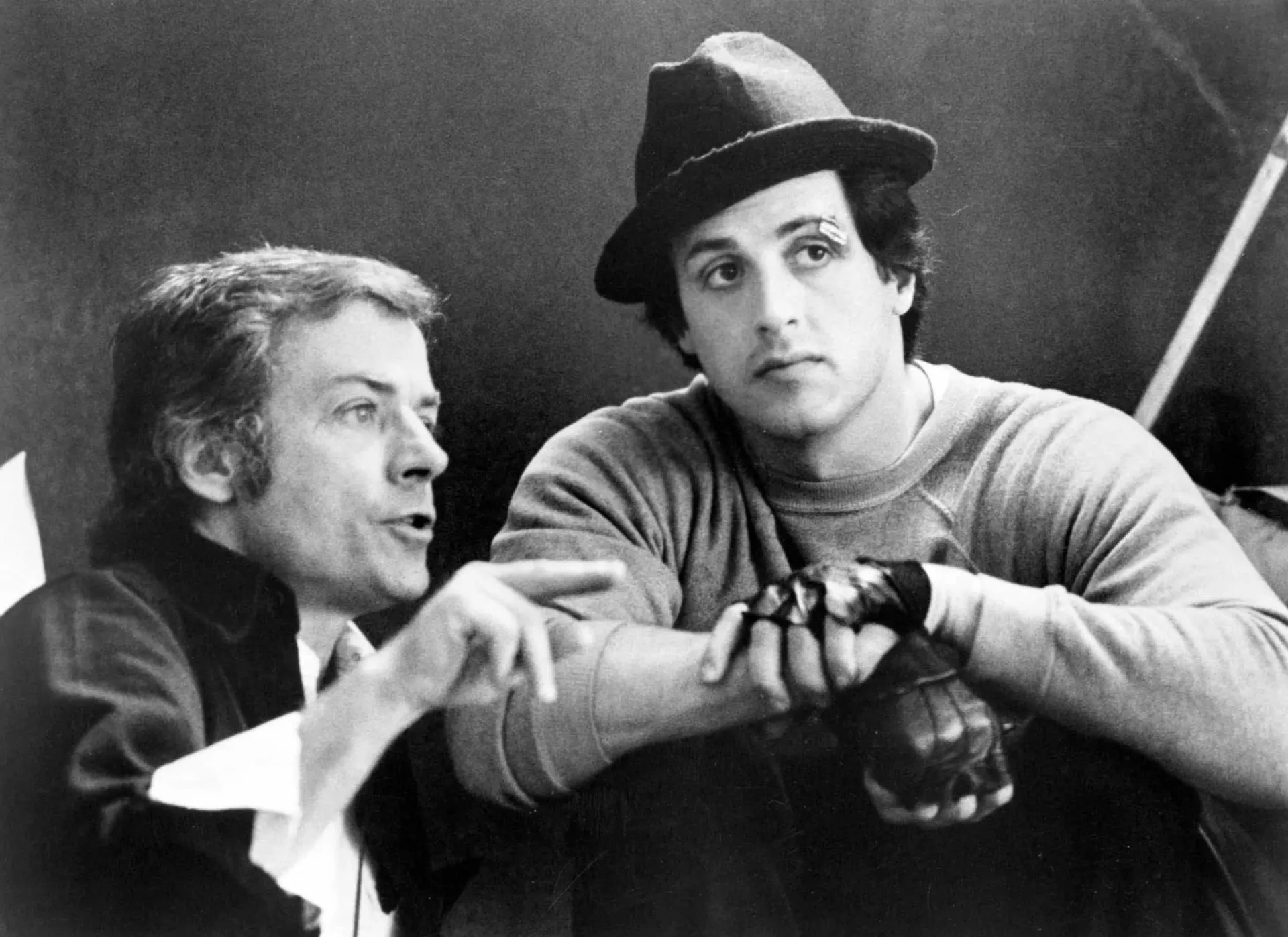 Sylvester Stallone como Rocky Balboa, com o rosto machucado, mas com olhar determinado no ringue.