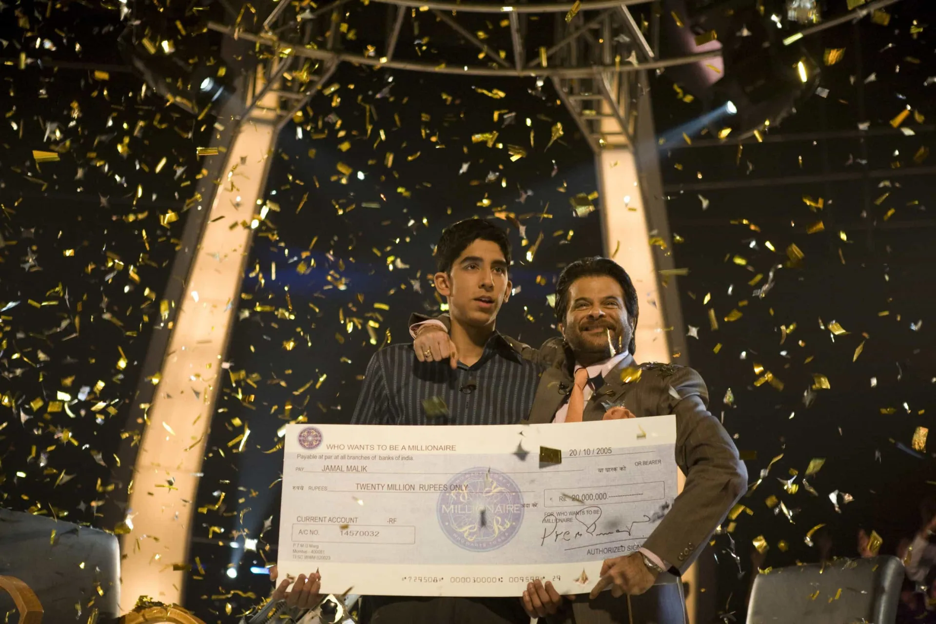 Dev Patel como Jamal Malik no programa de TV 'Quem Quer Ser um Milionário?'.
