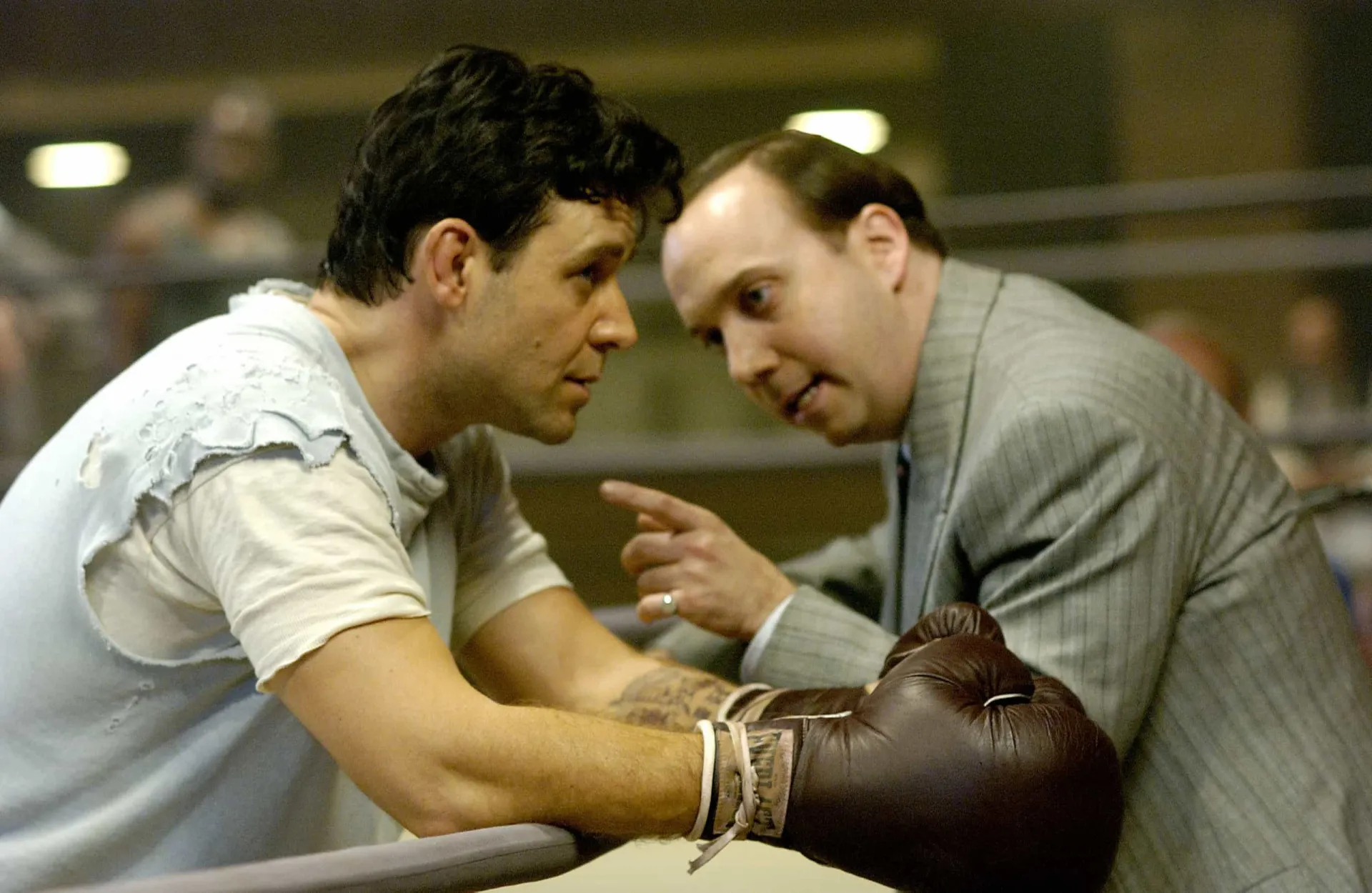 Russell Crowe como o boxeador James J. Braddock, lutando no ringue com determinação.