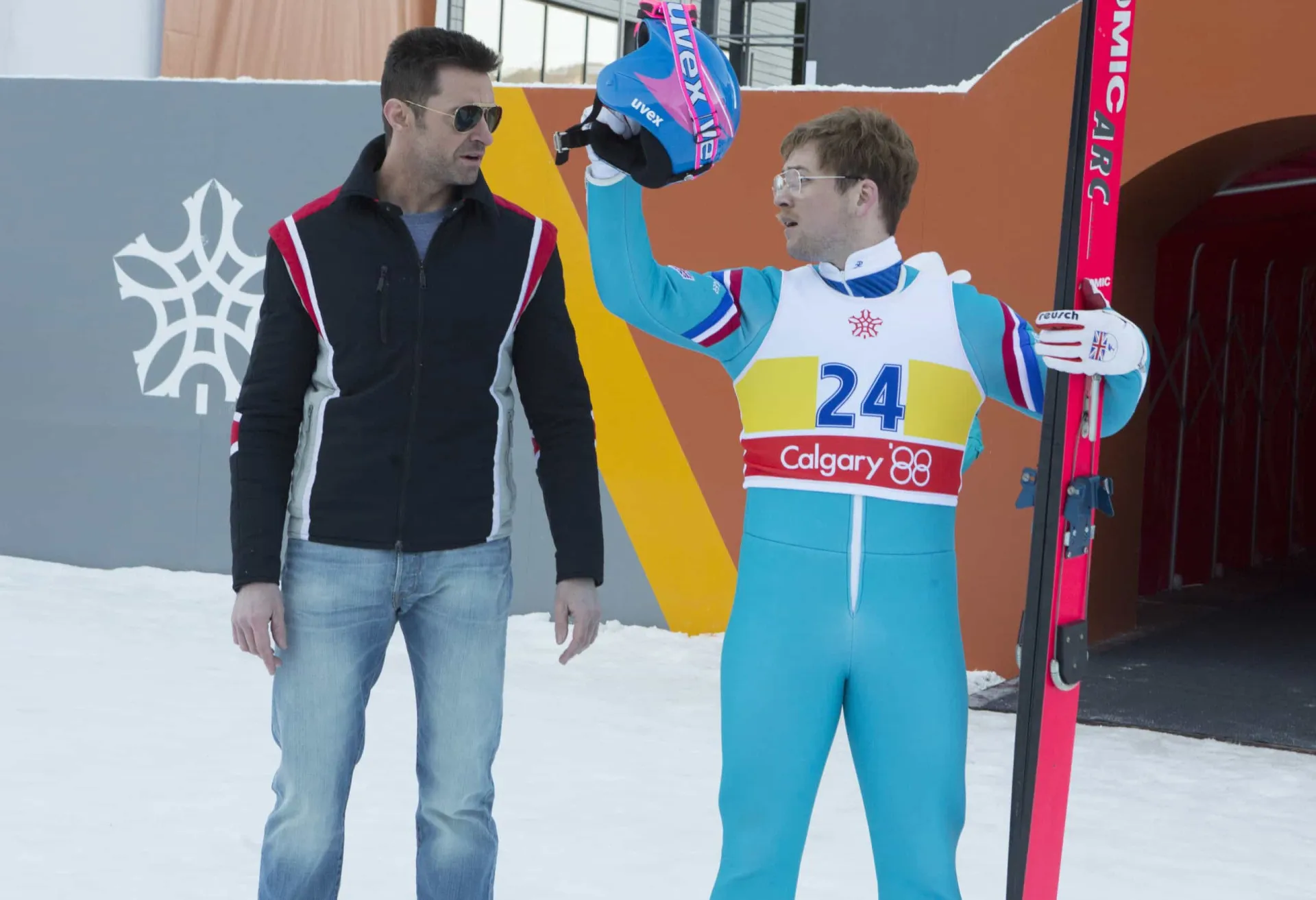 Taron Egerton como Eddie 'The Eagle' Edwards, sorrindo e usando equipamento de esqui.