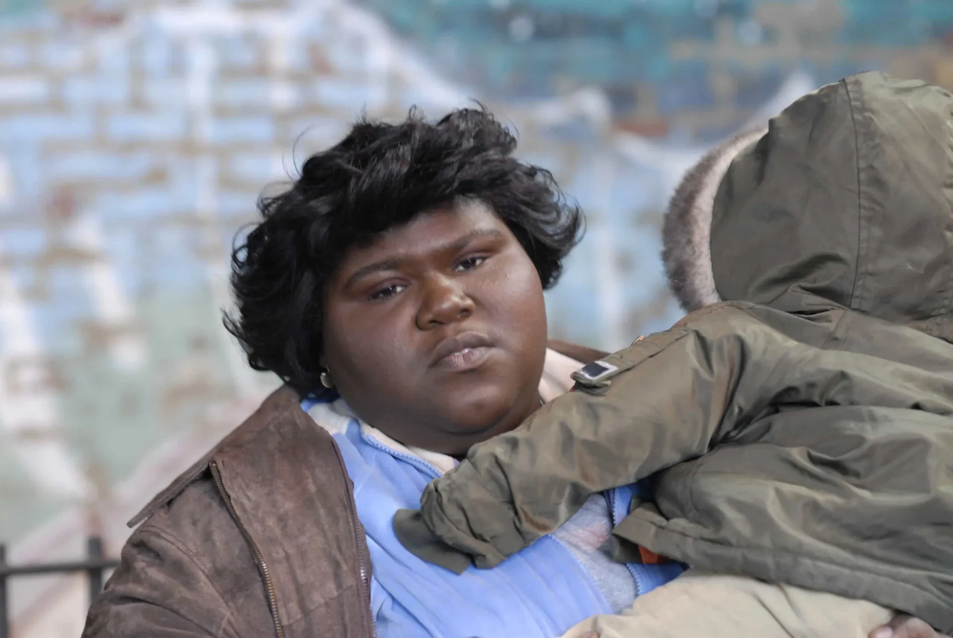Gabourey Sidibe como Preciosa, olhando para frente com um vislumbre de esperança no olhar.