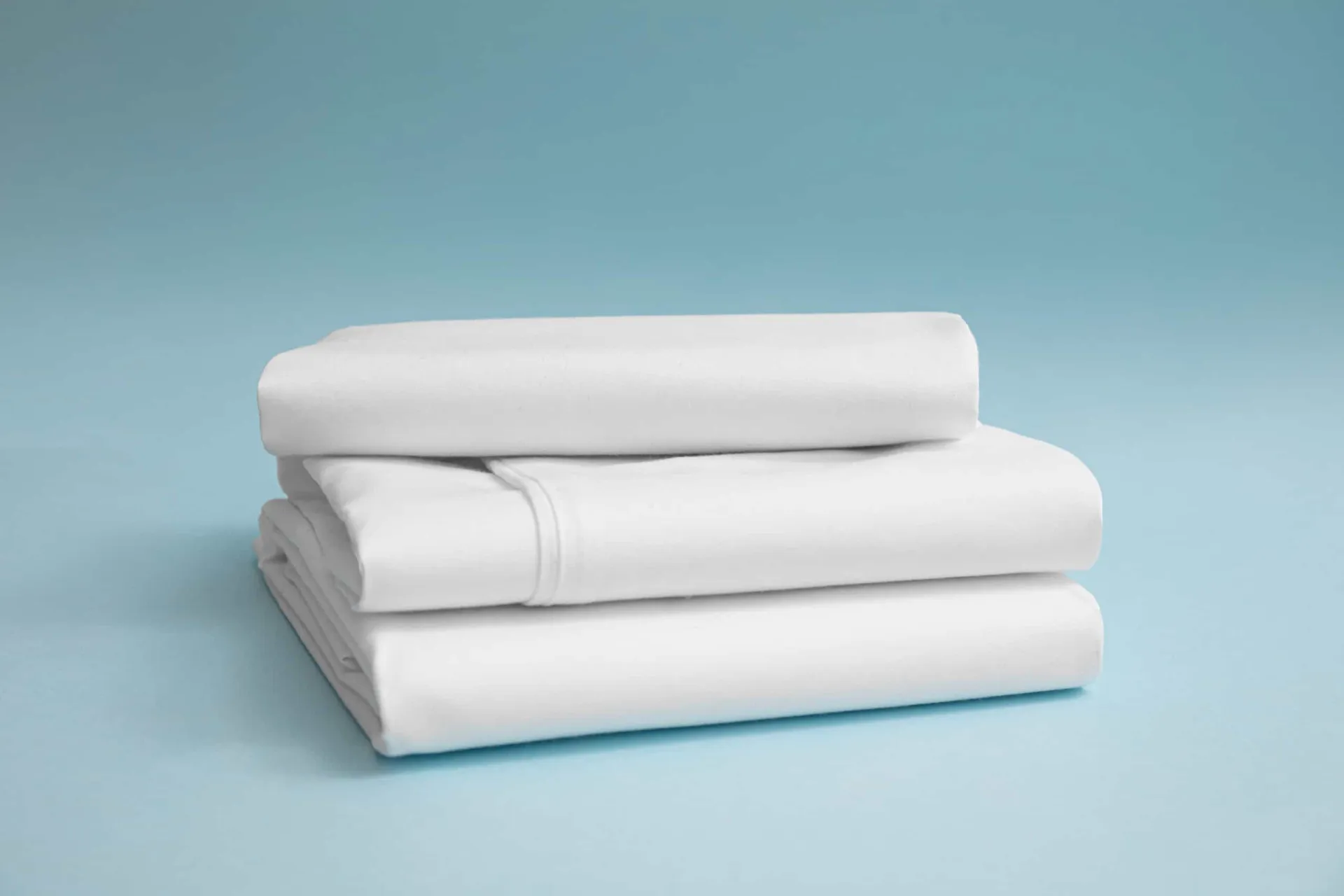 Cama desarrumada com lençóis que precisam ser trocados para evitar o acúmulo de partículas.