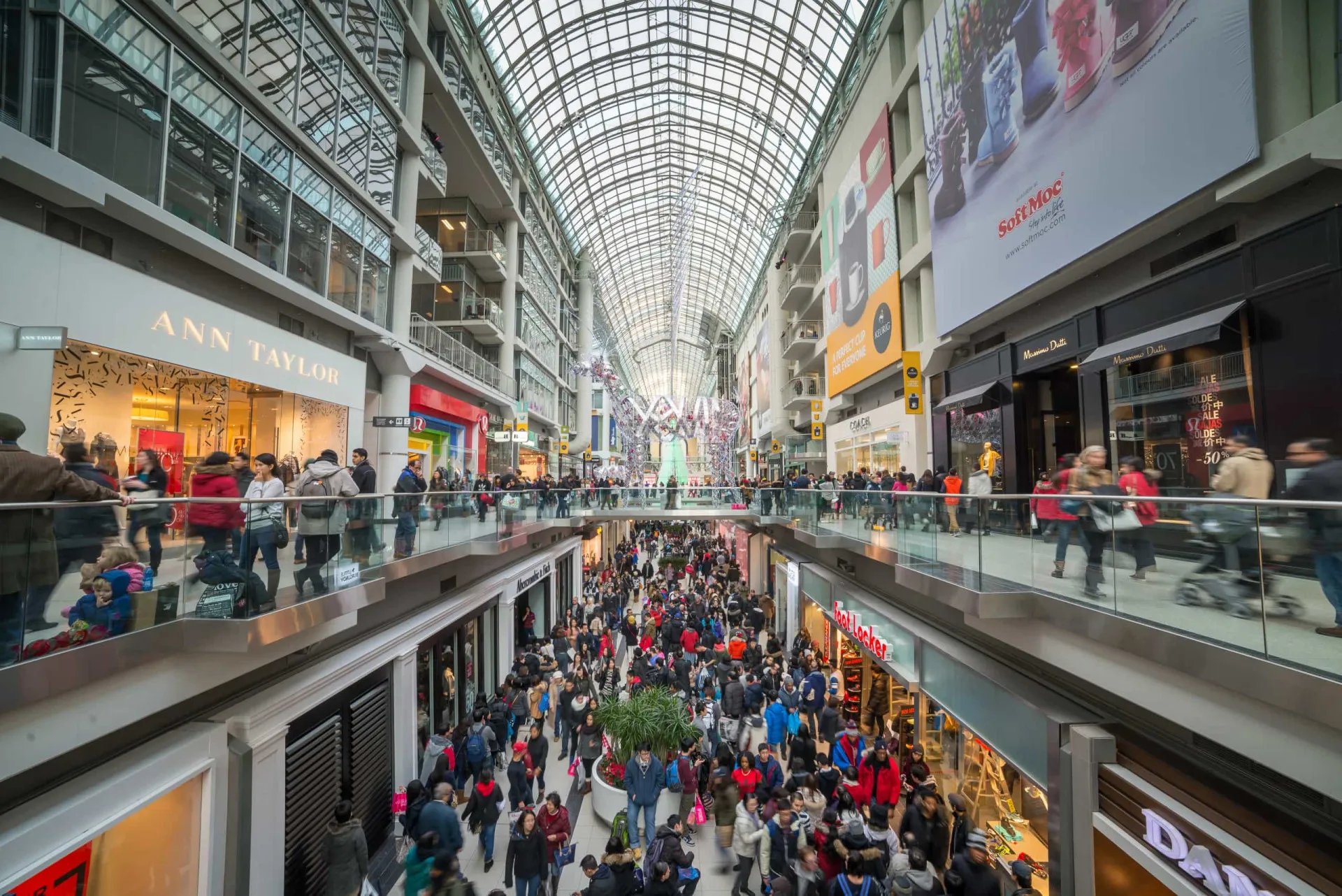 Multidão de pessoas andando em um shopping center movimentado.