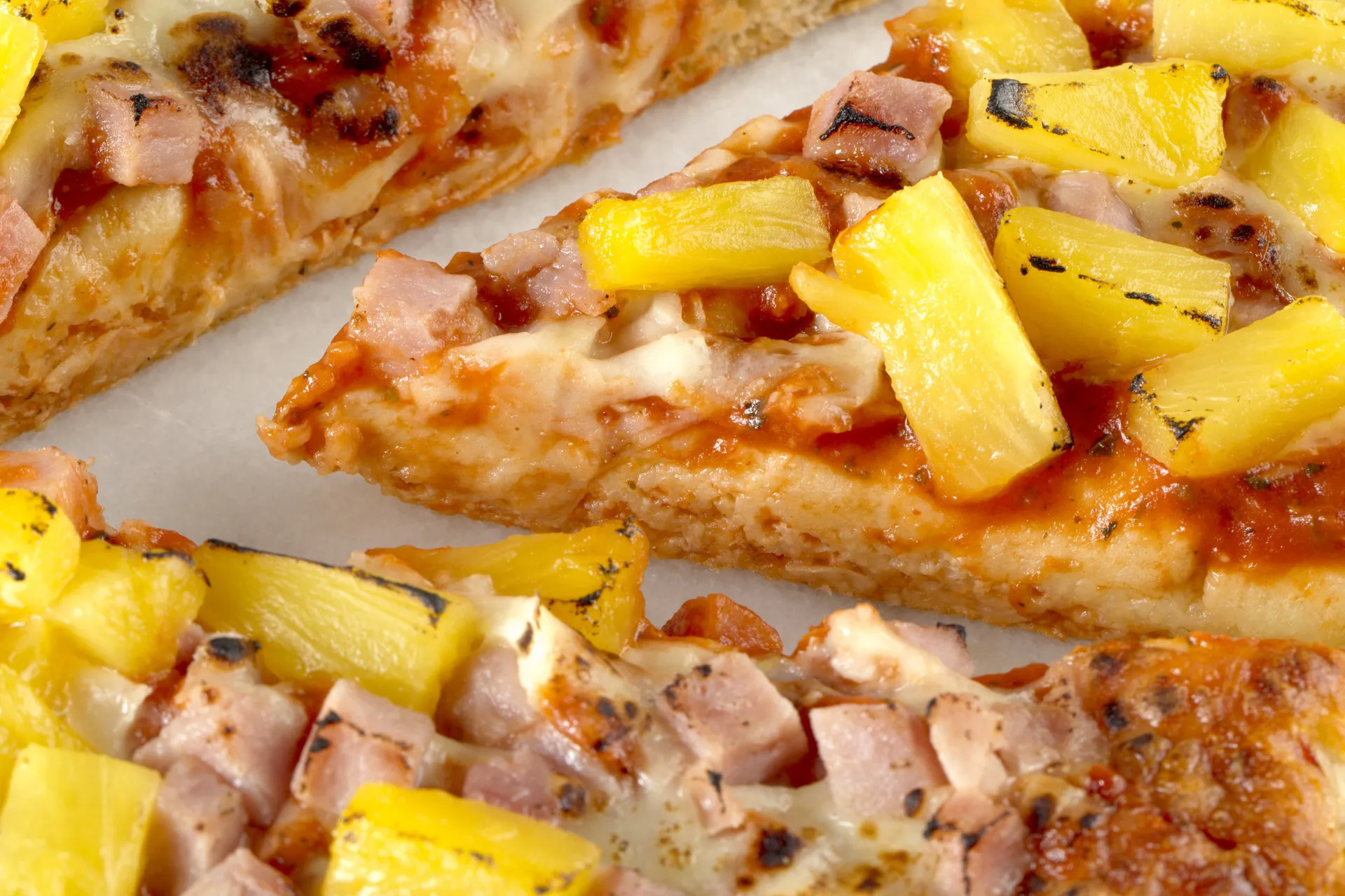 Pizza havaiana com cobertura de presunto e pedaços de abacaxi.