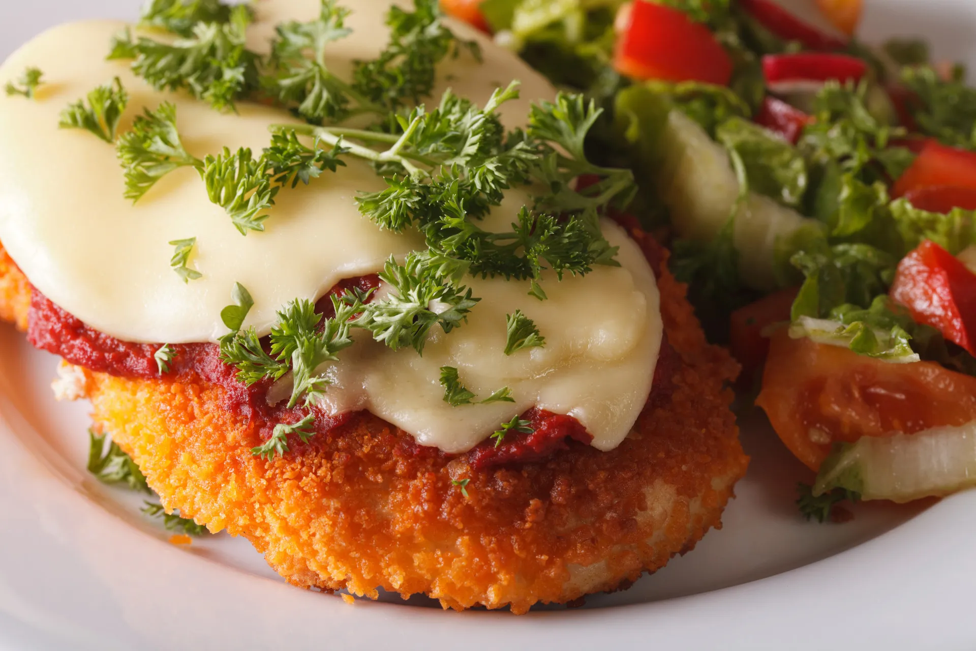 Travessa com berinjela à parmegiana, com camadas de berinjela, molho e queijo derretido.