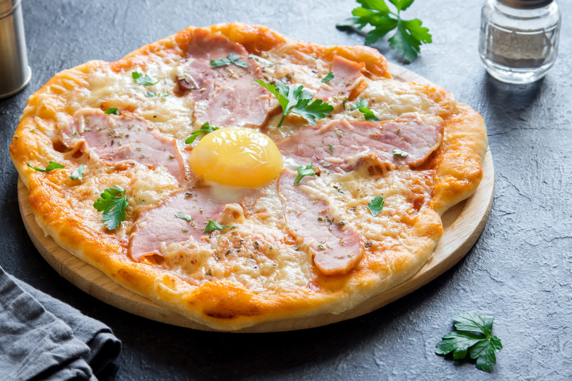 Pizza coberta com ingredientes de carbonara, como ovo, bacon e queijo.