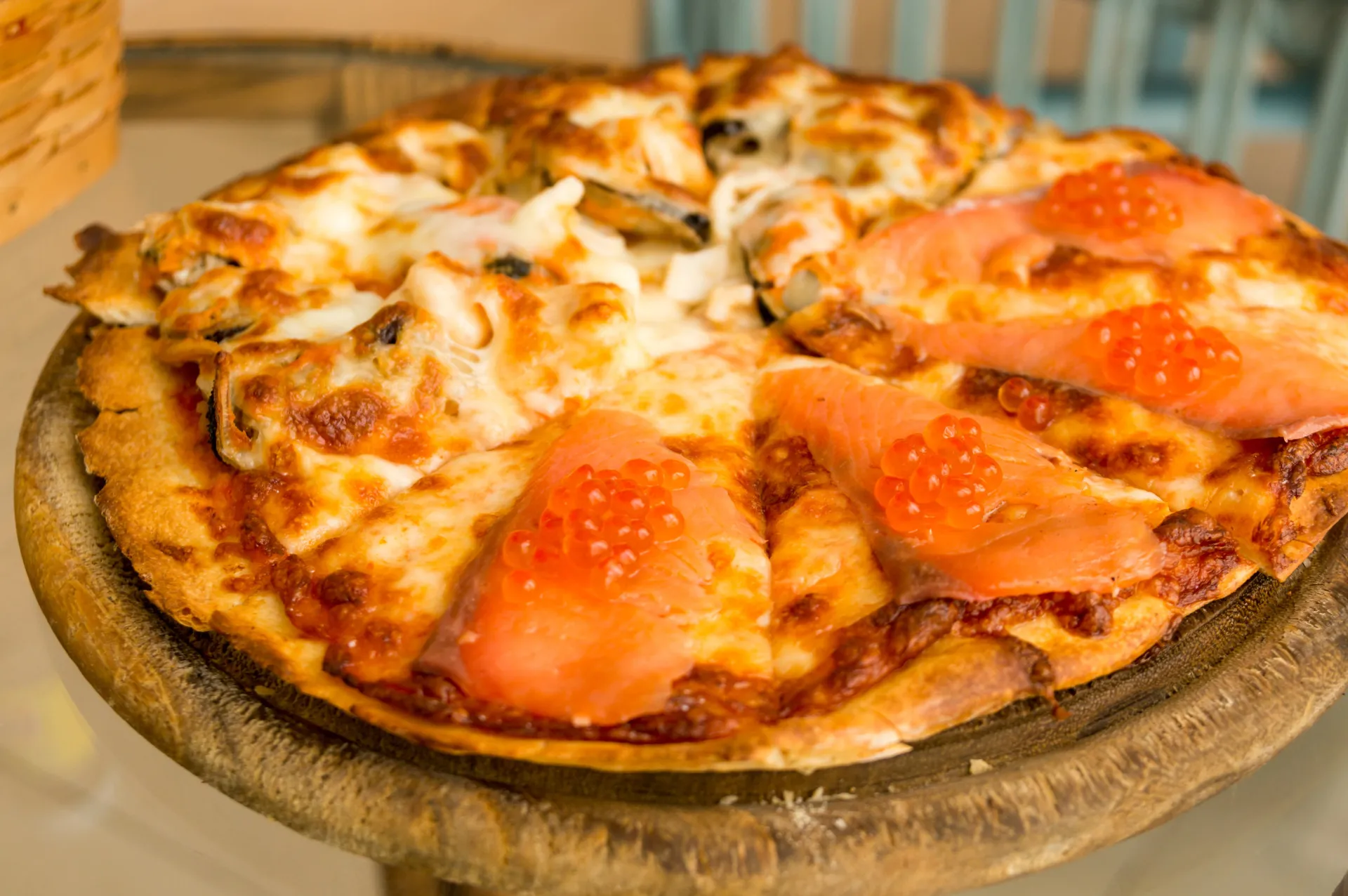 Pizza de sushi, com uma base de arroz frito coberta com peixe cru, abacate e outros ingredientes de sushi.