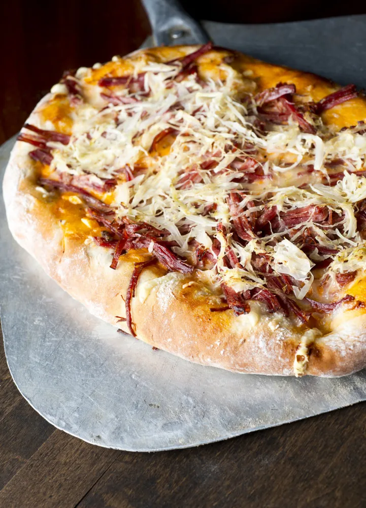 Pizza coberta com chucrute (sauerkraut) e salsichas, uma combinação tipicamente alemã.