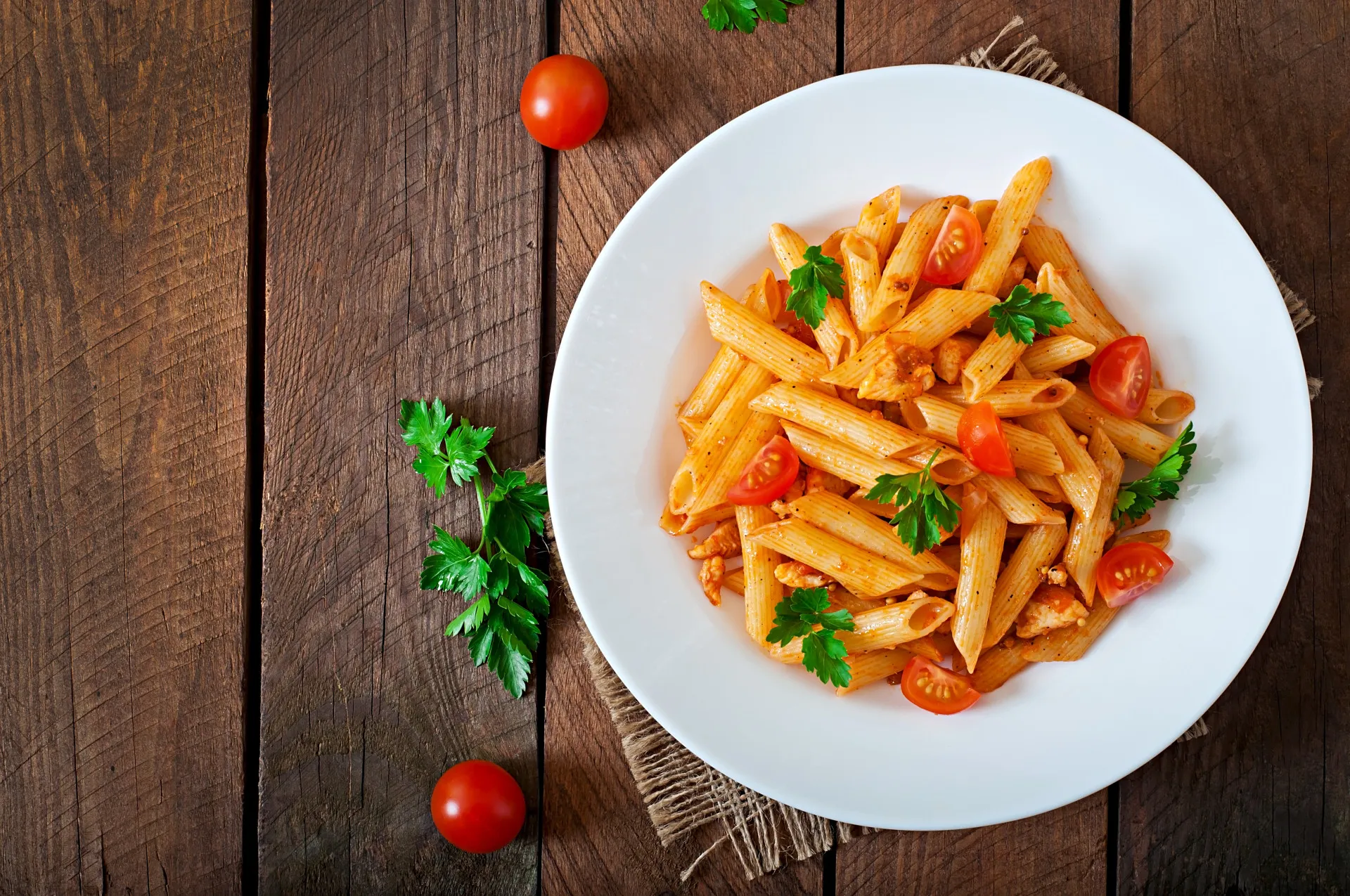 Prato de macarrão com molho vermelho e manjericão.