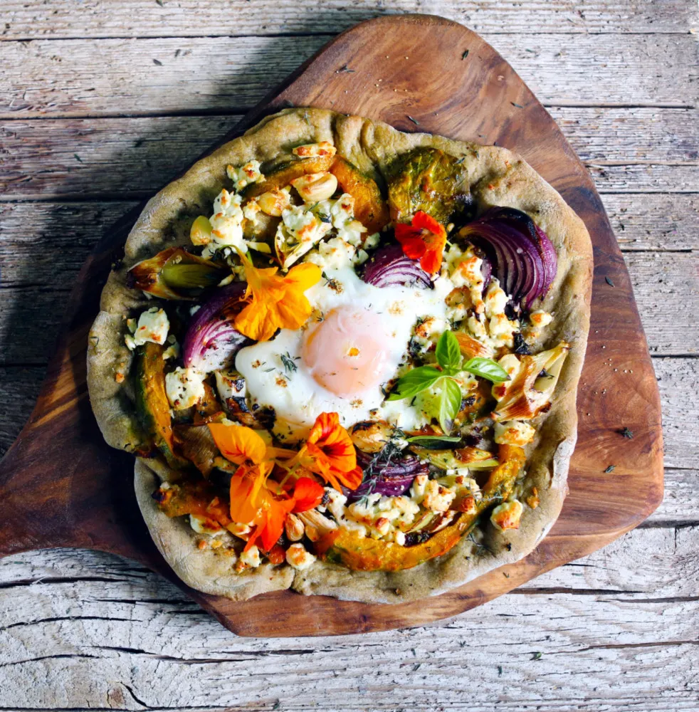 Pizza sobrecarregada com dezenas de ingredientes diferentes, quase não se vê a massa.