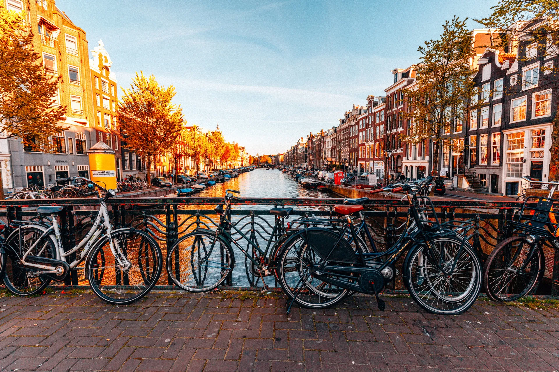 Canais pitorescos de Amsterdã com bicicletas estacionadas ao longo da margem.