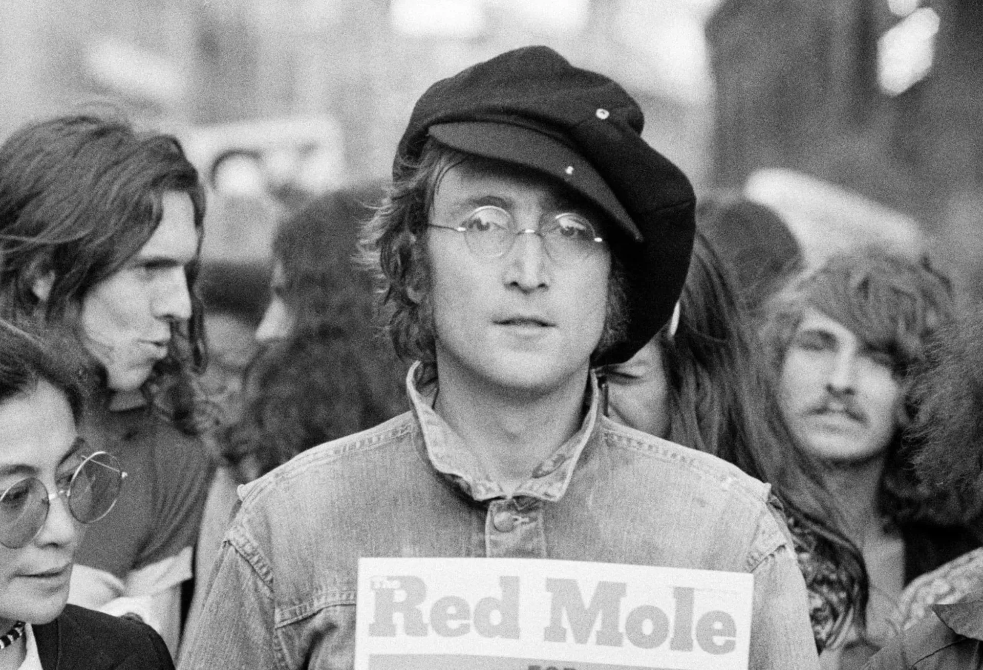 John Lennon usando seus icônicos óculos redondos.