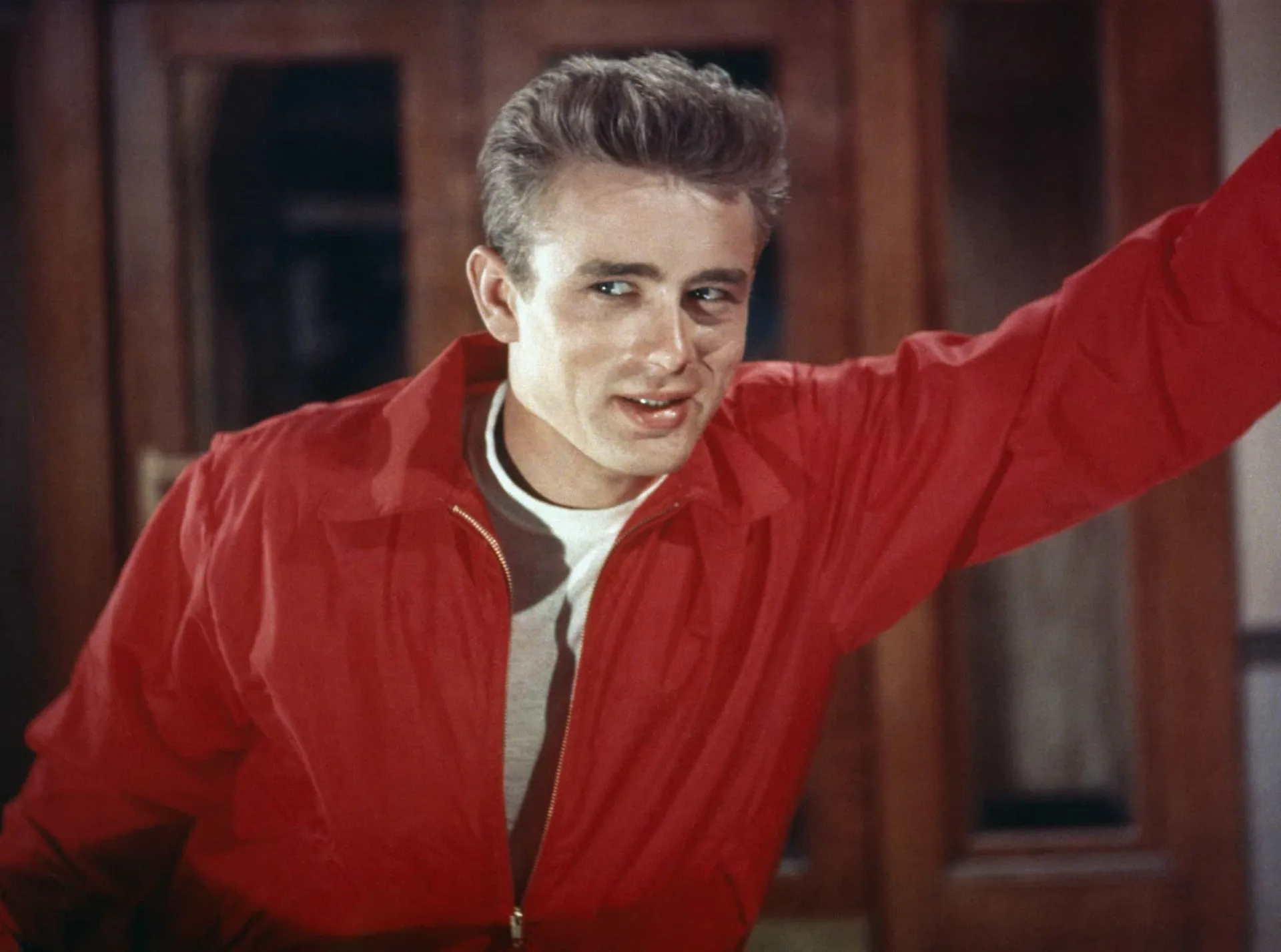 O ator James Dean com um cigarro na boca, olhando intensamente para a câmera.