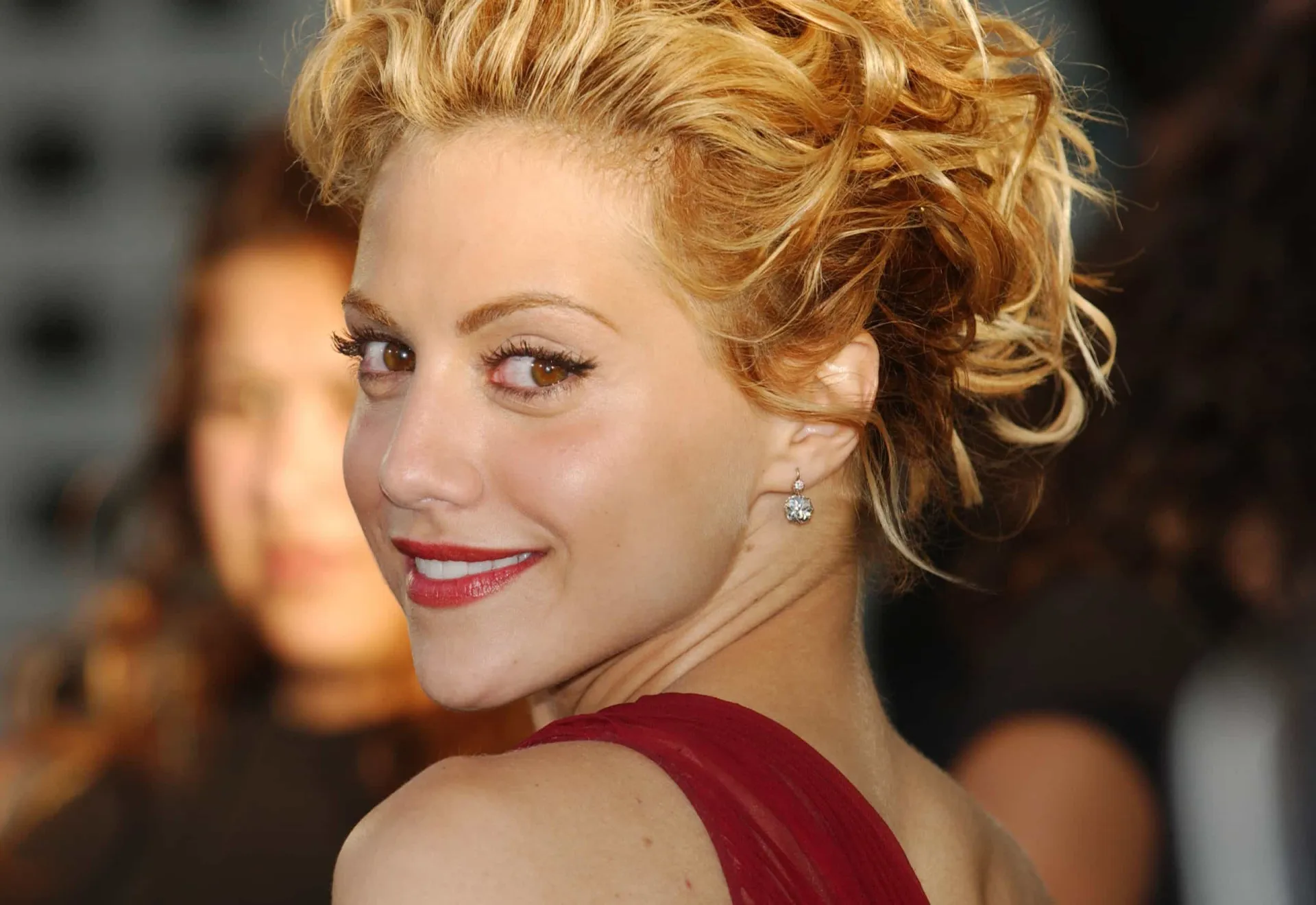 A atriz Brittany Murphy com um olhar pensativo em um evento.