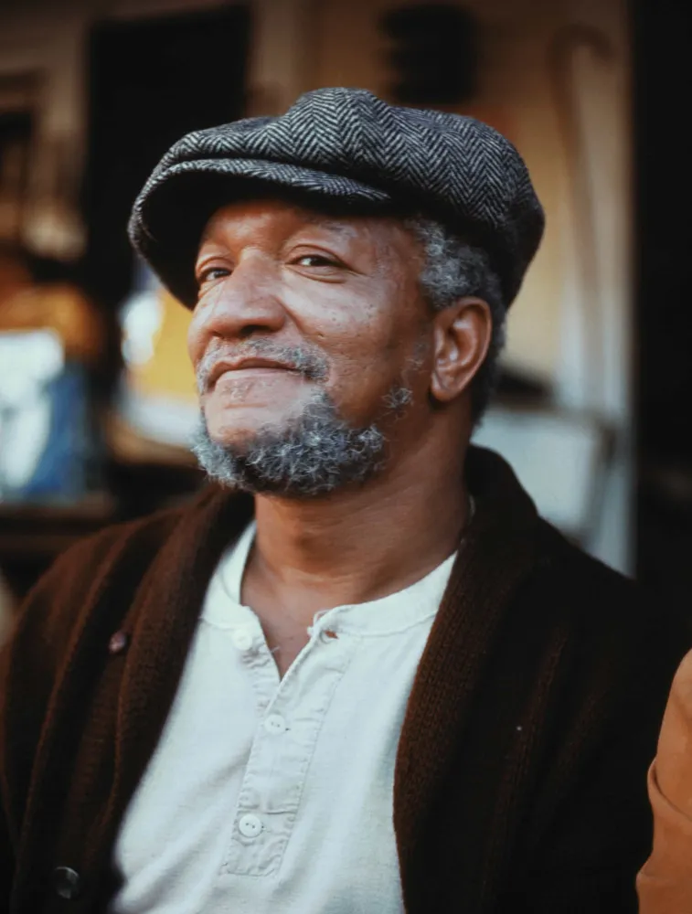 O comediante Redd Foxx sorrindo largamente.
