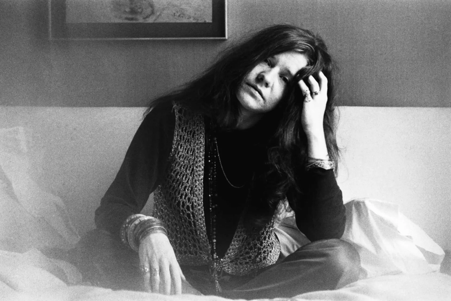 A cantora Janis Joplin cantando intensamente em um microfone.