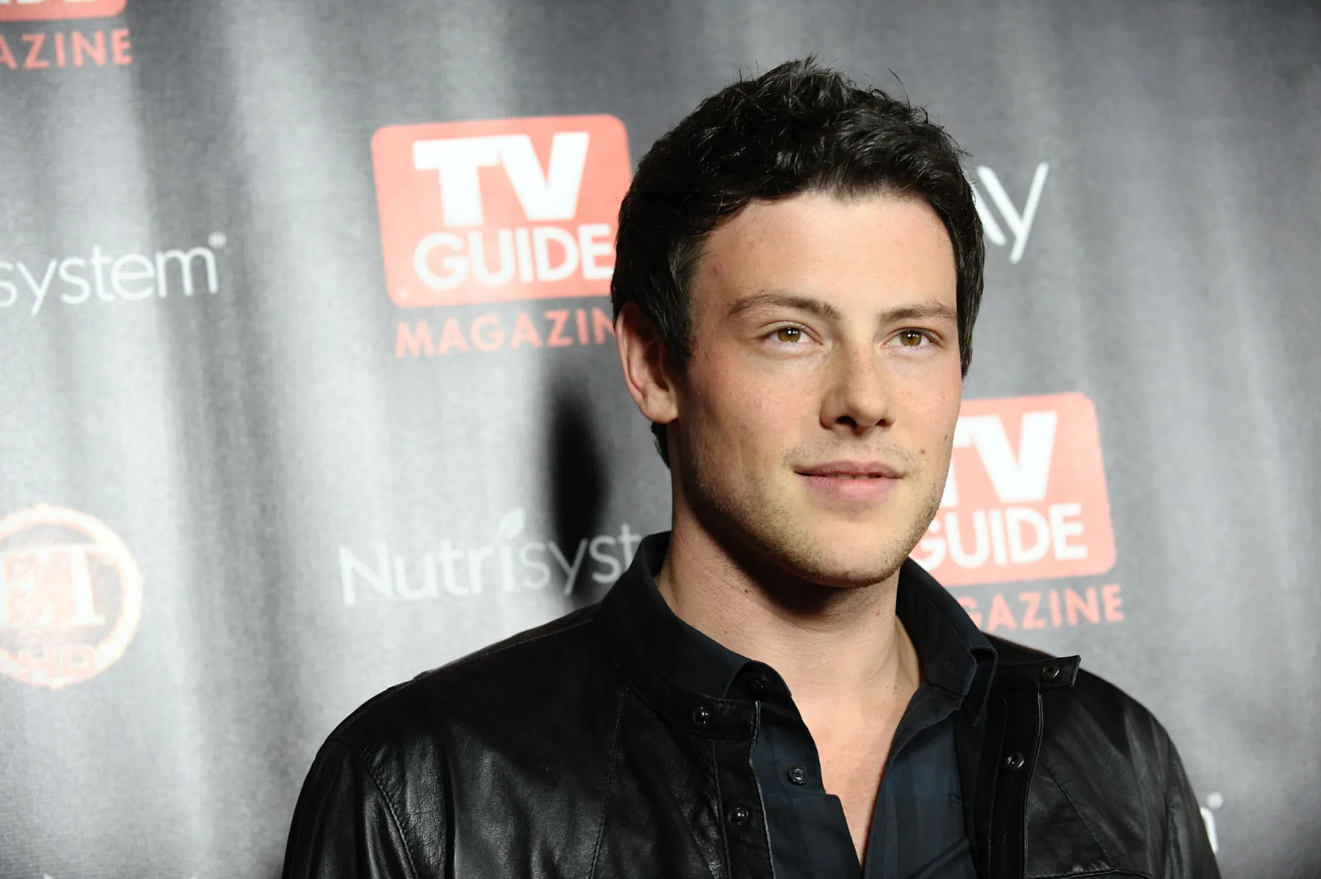 O ator Cory Monteith, de 'Glee', sorrindo para a câmera.