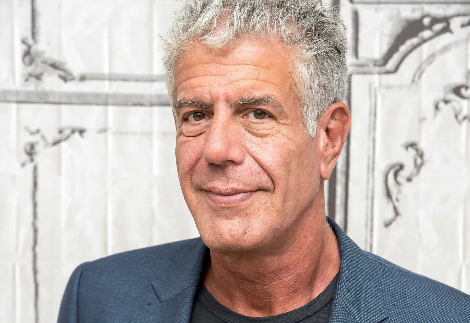 O chef e apresentador Anthony Bourdain com um olhar sério e pensativo.