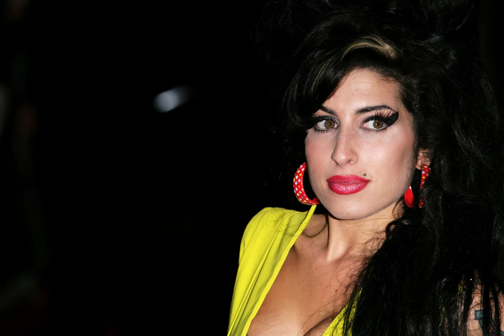 A cantora Amy Winehouse com seu penteado icônico e maquiagem marcante.