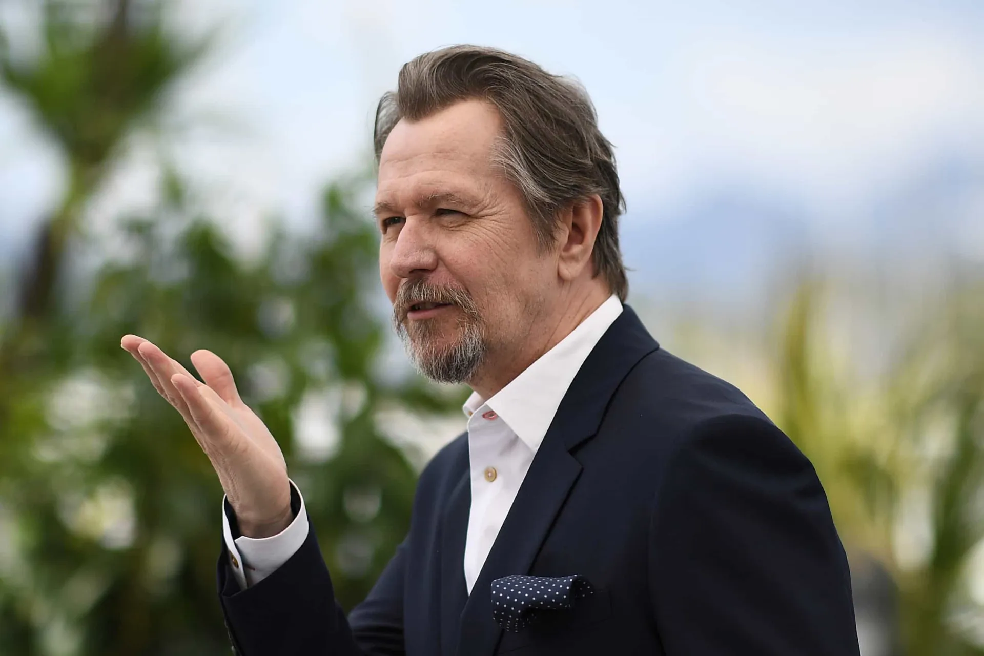Gary Oldman e sua atual esposa, Gisele Schmidt, sorrindo juntos.