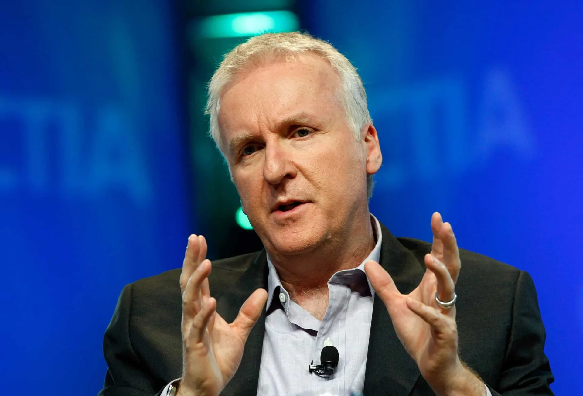 James Cameron e sua esposa, Suzy Amis, sorrindo juntos em um evento.